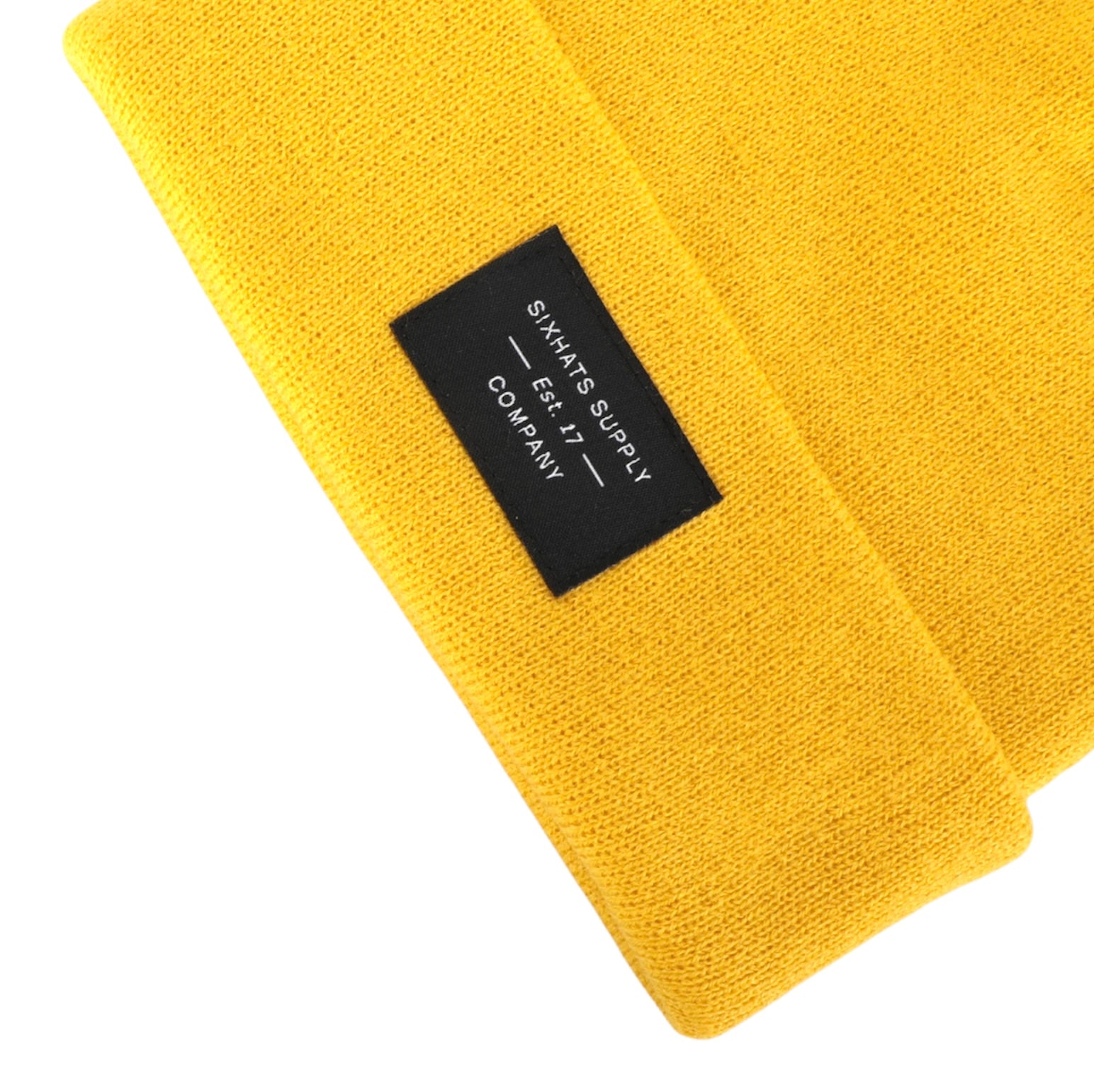 A vibrant yellow folding beanie made from soft, moisture-wicking material, perfect for stylish warmth in cold weather.