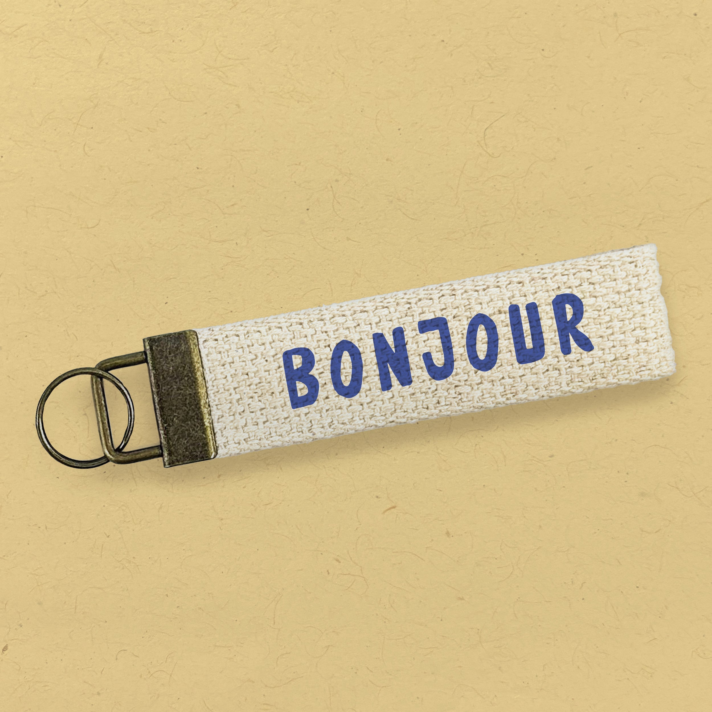 Bonjour Canvas Key Fob featuring heavy duty cotton webbing and durable bronze hardware in a natural color.