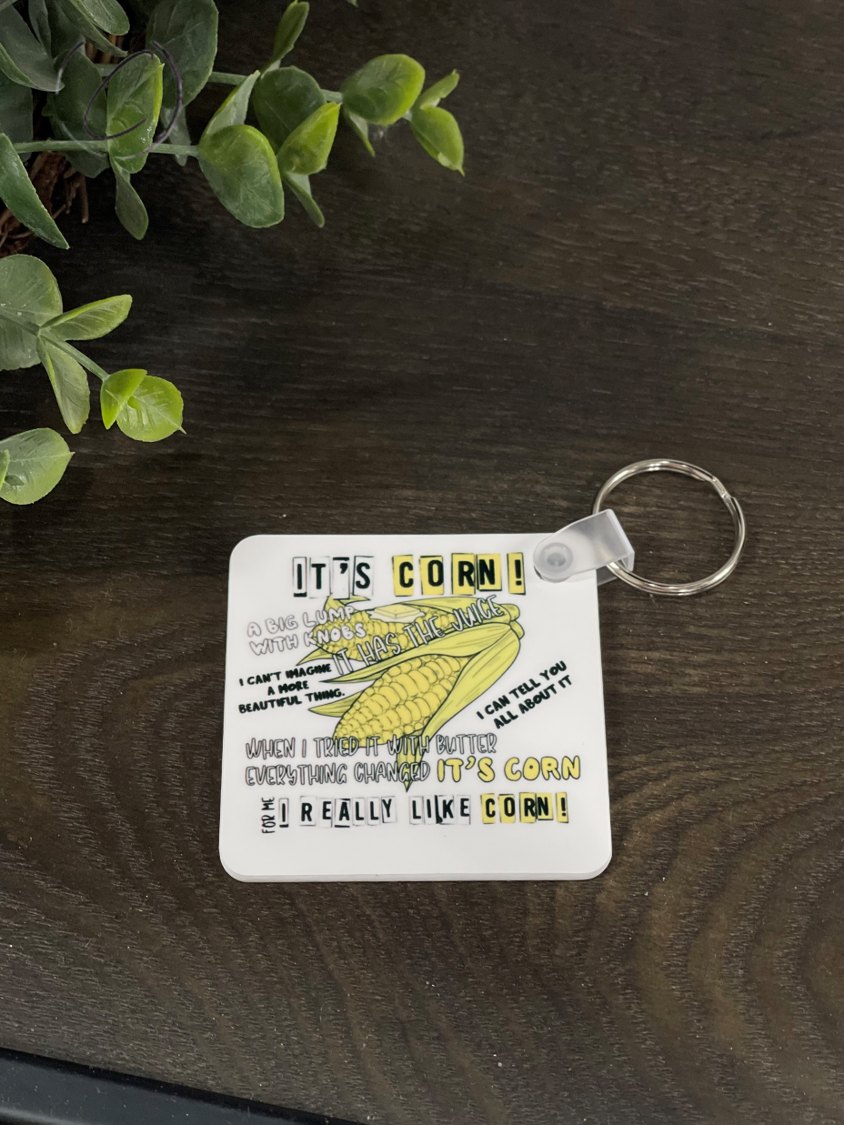 It's Corn! Keychain featuring a vibrant corn design on both sides, made from durable plastic, measuring 2.25 inches square.