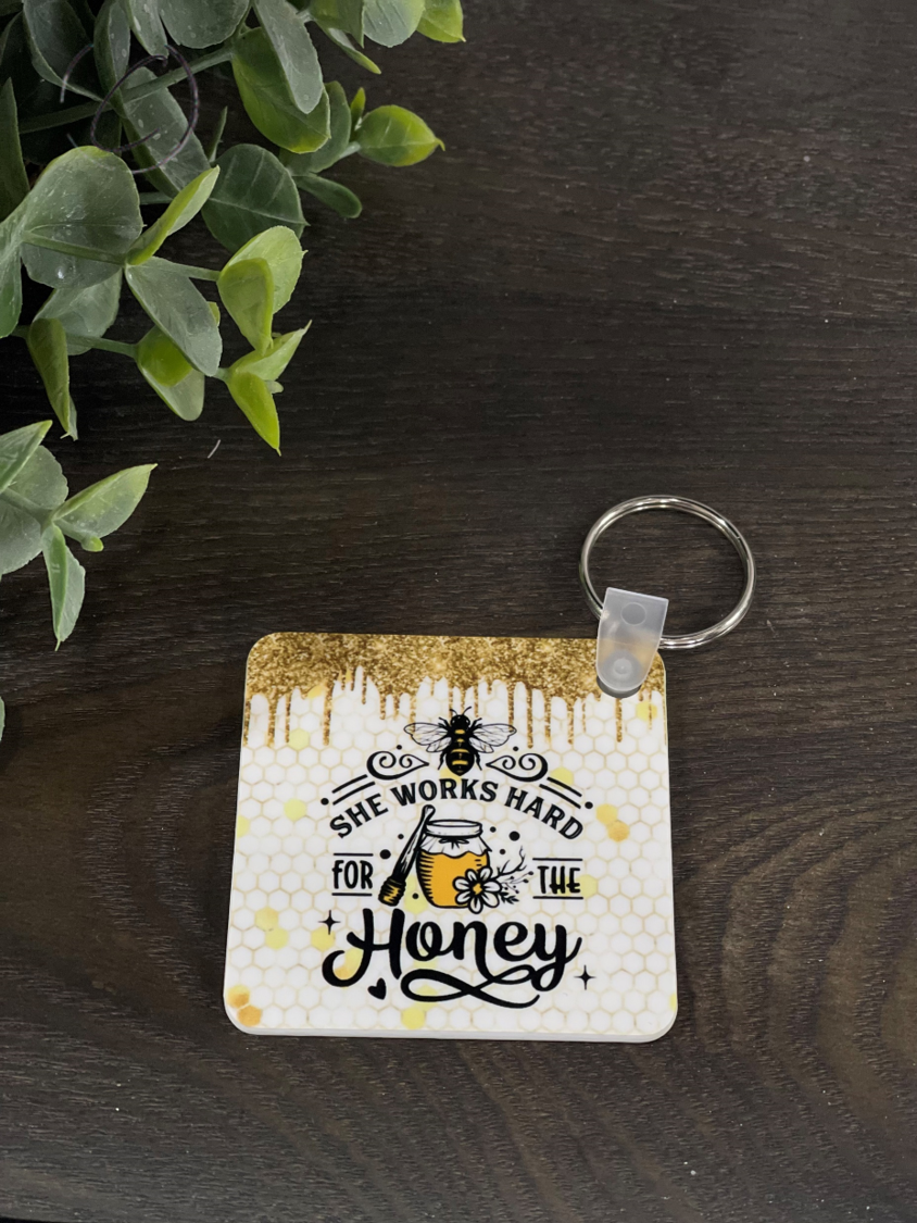 She Works Hard For The Honey Keychain featuring a vibrant double-sided design, made from durable plastic, measuring 2.25 inches square.