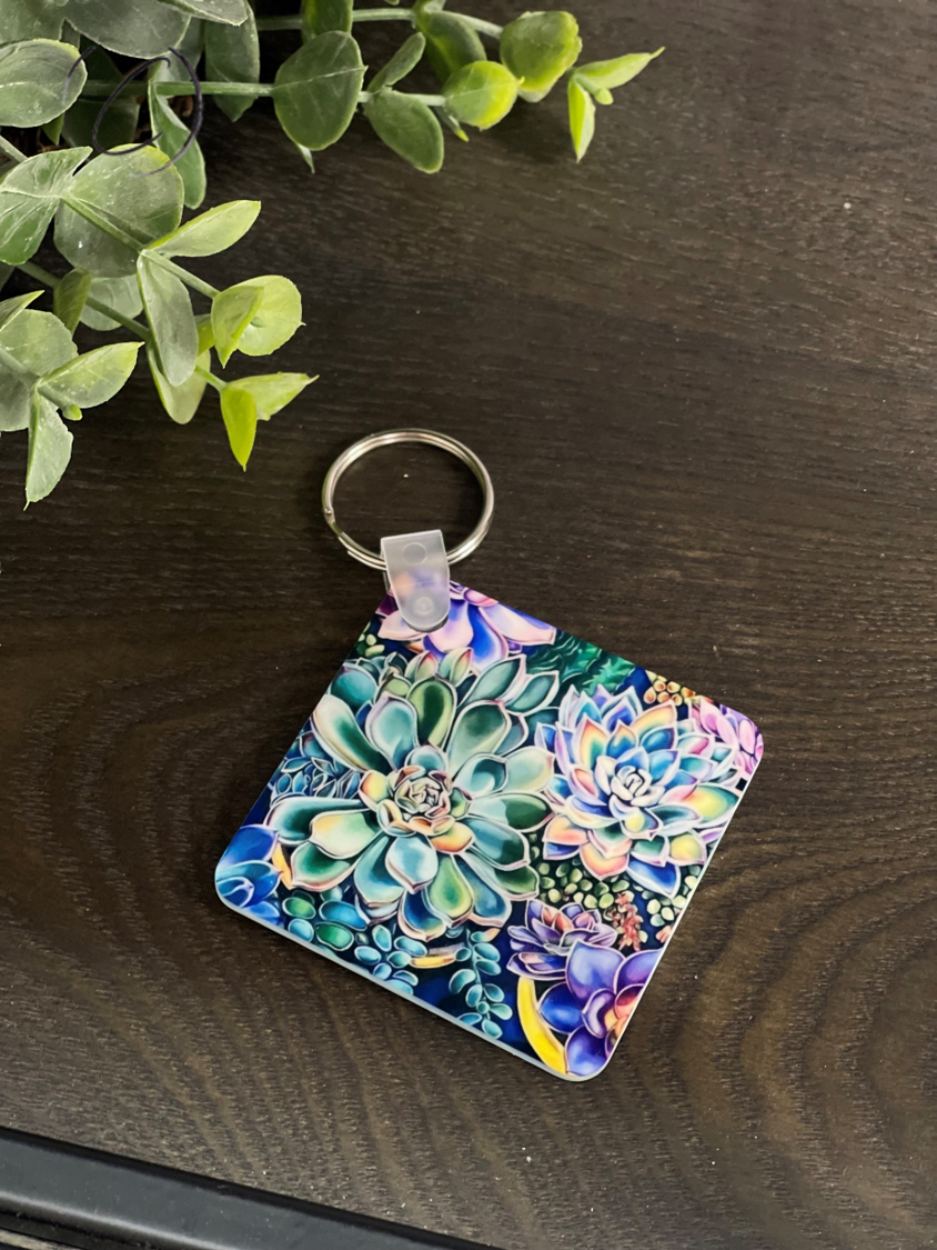 A vibrant double-sided succulent keychain made from durable plastic, measuring 2.25 inches by 2.25 inches, showcasing intricate succulent designs.