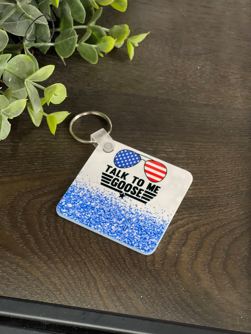 A vibrant Talk To Me Goose Keychain featuring a double-sided design, made from durable plastic, measuring 2.25 inches by 2.25 inches.