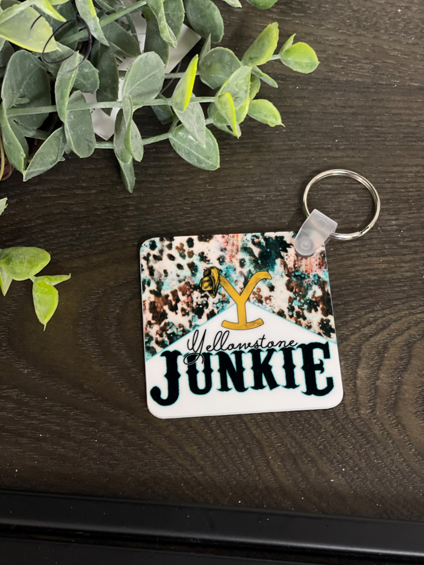 Yellowstone Junkie Keychain featuring a vibrant double-sided design, made from durable plastic, measuring 2.25 inches by 2.25 inches.