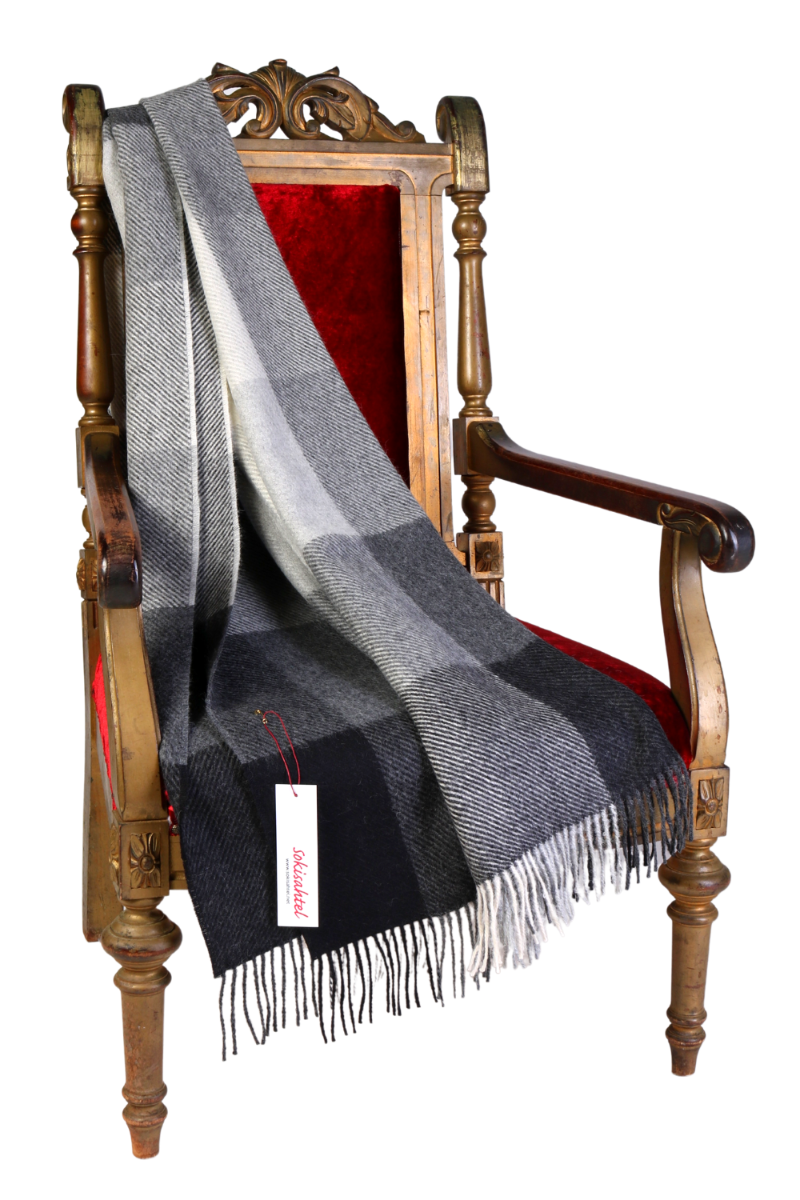 Luxurious grey and black chequered alpaca wool plaid, showcasing its soft texture and elegant design, perfect for winter warmth.