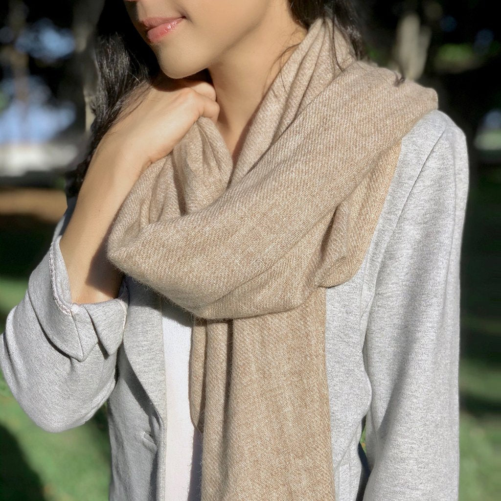 A luxurious beige handloom cashmere scarf, showcasing its soft texture and oversized design, perfect for layering in cold weather.