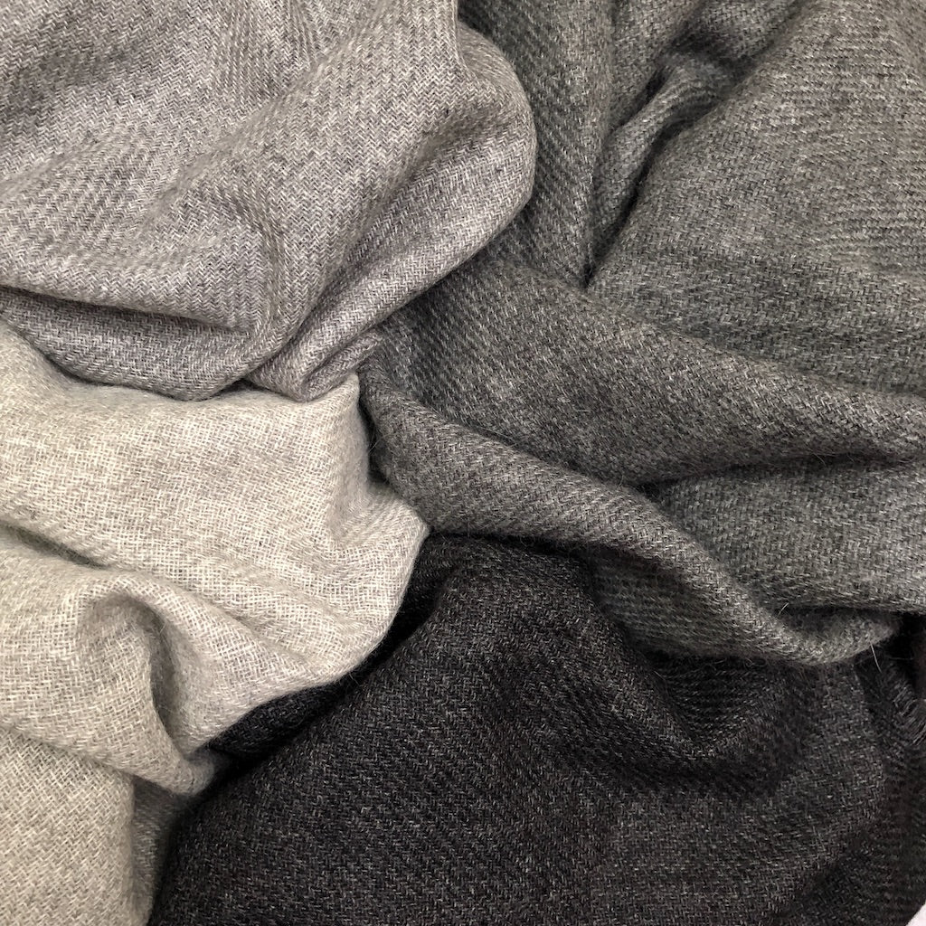 A luxurious charcoal handloom cashmere scarf, showcasing its soft texture and unique patterns, perfect for cold weather layering.