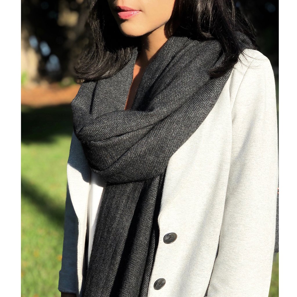 A luxurious charcoal handloom cashmere scarf, showcasing its soft texture and unique patterns, perfect for cold weather layering.