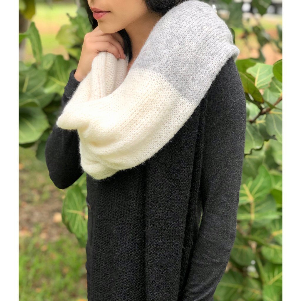 A luxurious Color Block Alpaca Wrap Scarf featuring a delicate eyelet design, showcasing shades of black, gray, and snow, perfect for layering.