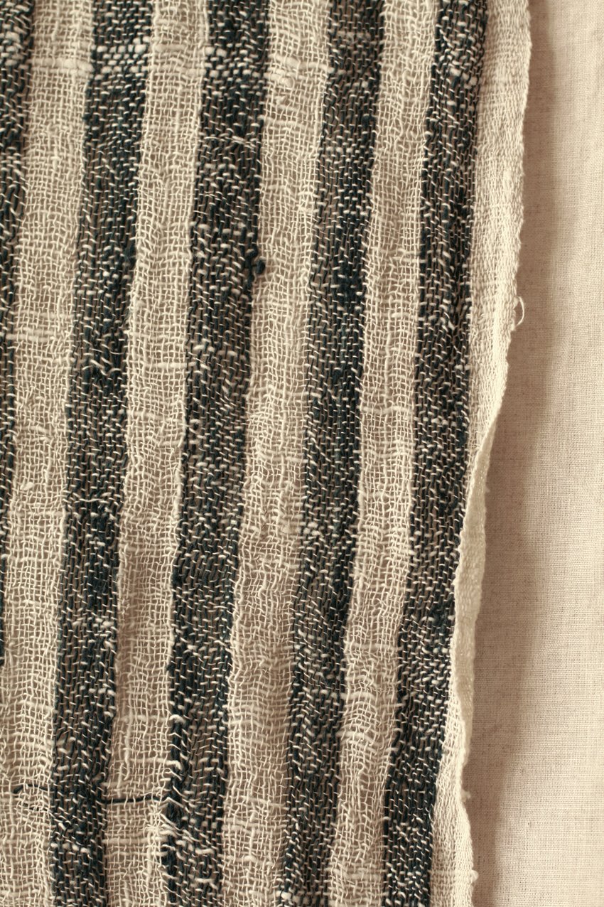 Fatima Hand-loomed Raw Cotton Scarf in Black with striped texture and fringe knots, showcasing artisanal craftsmanship.