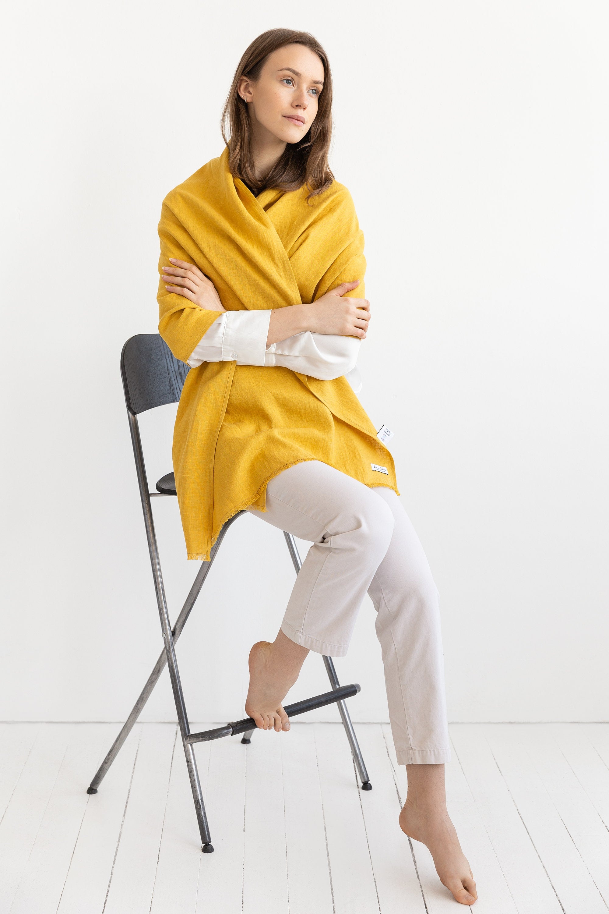 A vibrant Honey linen scarf made from 100% stonewashed linen, showcasing its soft texture and stylish design.