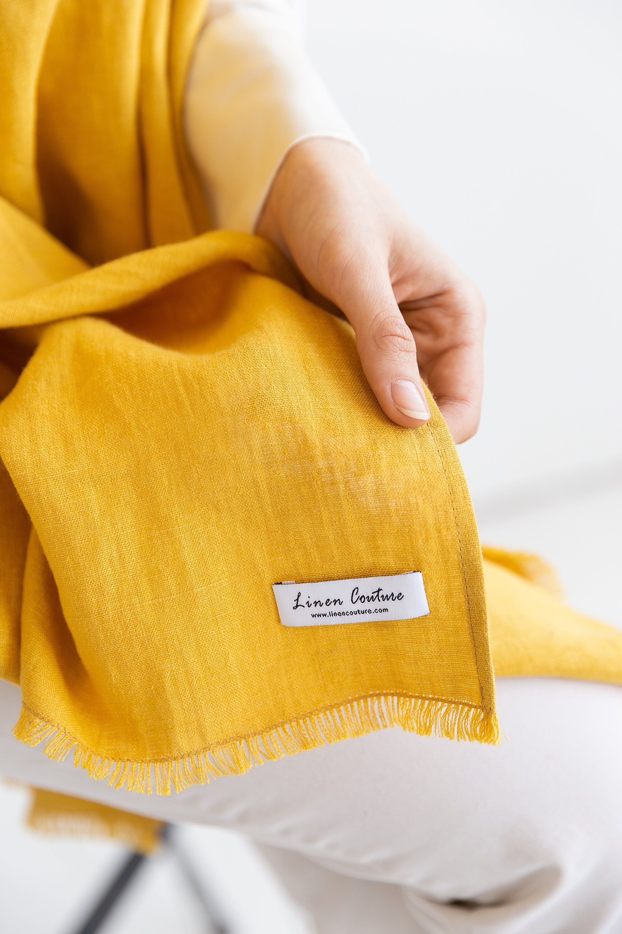 A vibrant Honey linen scarf made from 100% stonewashed linen, showcasing its soft texture and stylish design.