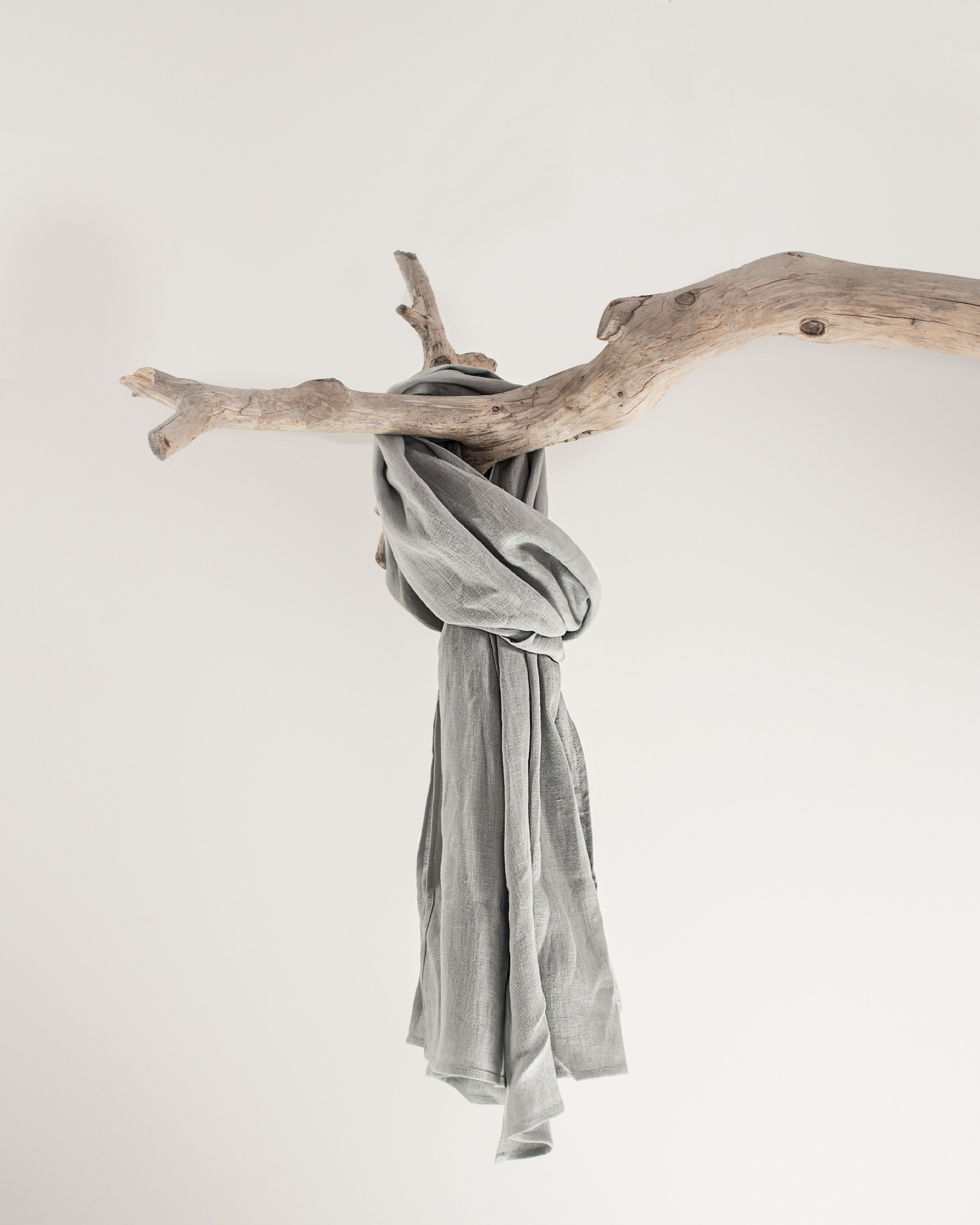 A light grey linen scarf made from 100% stonewashed linen, showcasing its soft texture and elegant design.