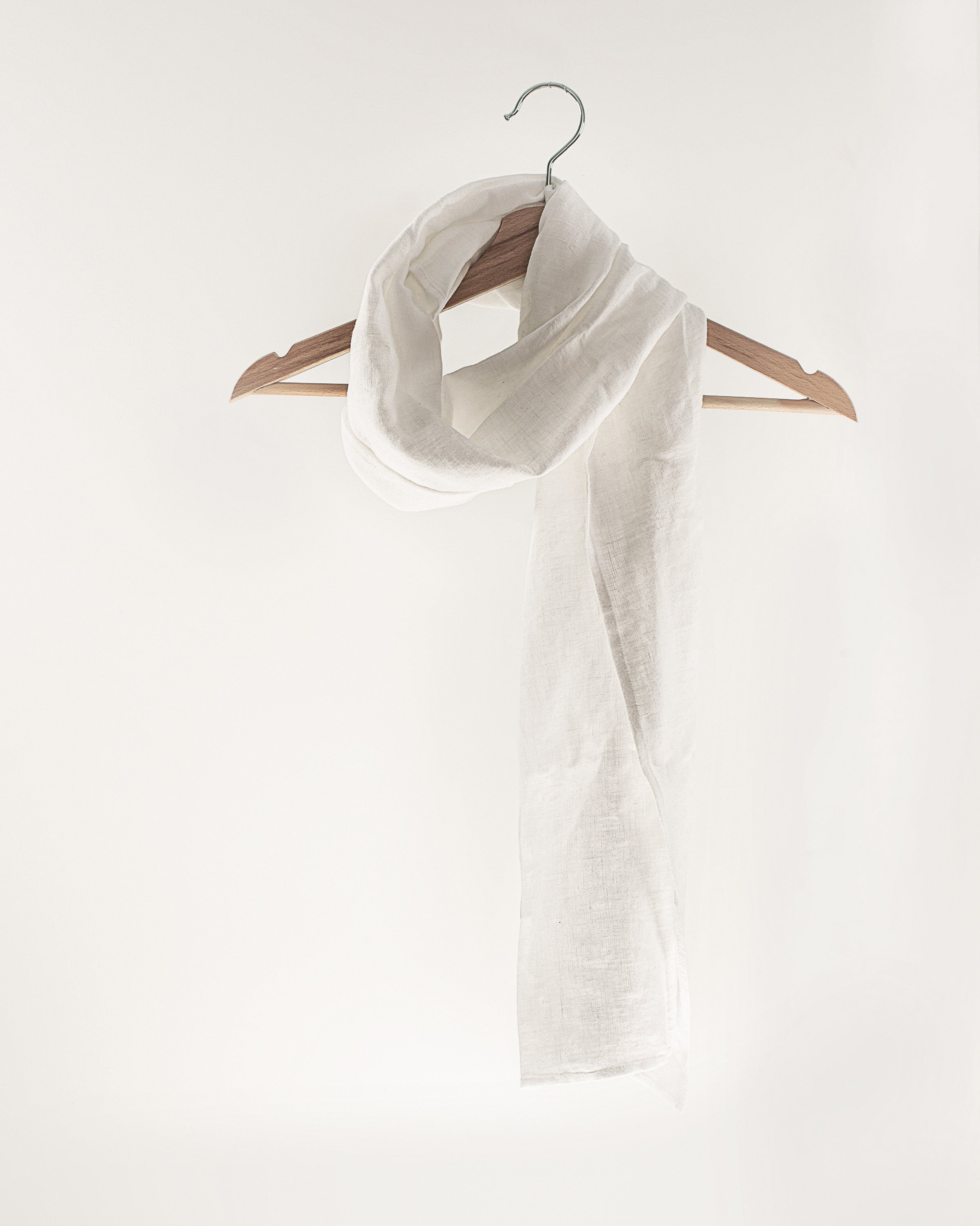 A light grey linen scarf made from 100% stonewashed linen, showcasing its soft texture and elegant design.