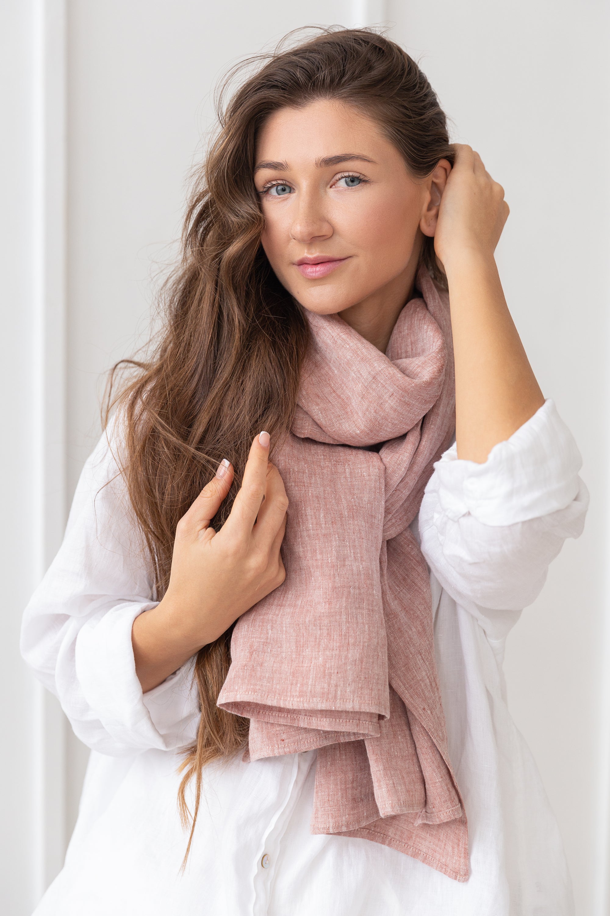 A lightweight Pale Pink linen scarf draped elegantly, showcasing its soft texture and stylish design.