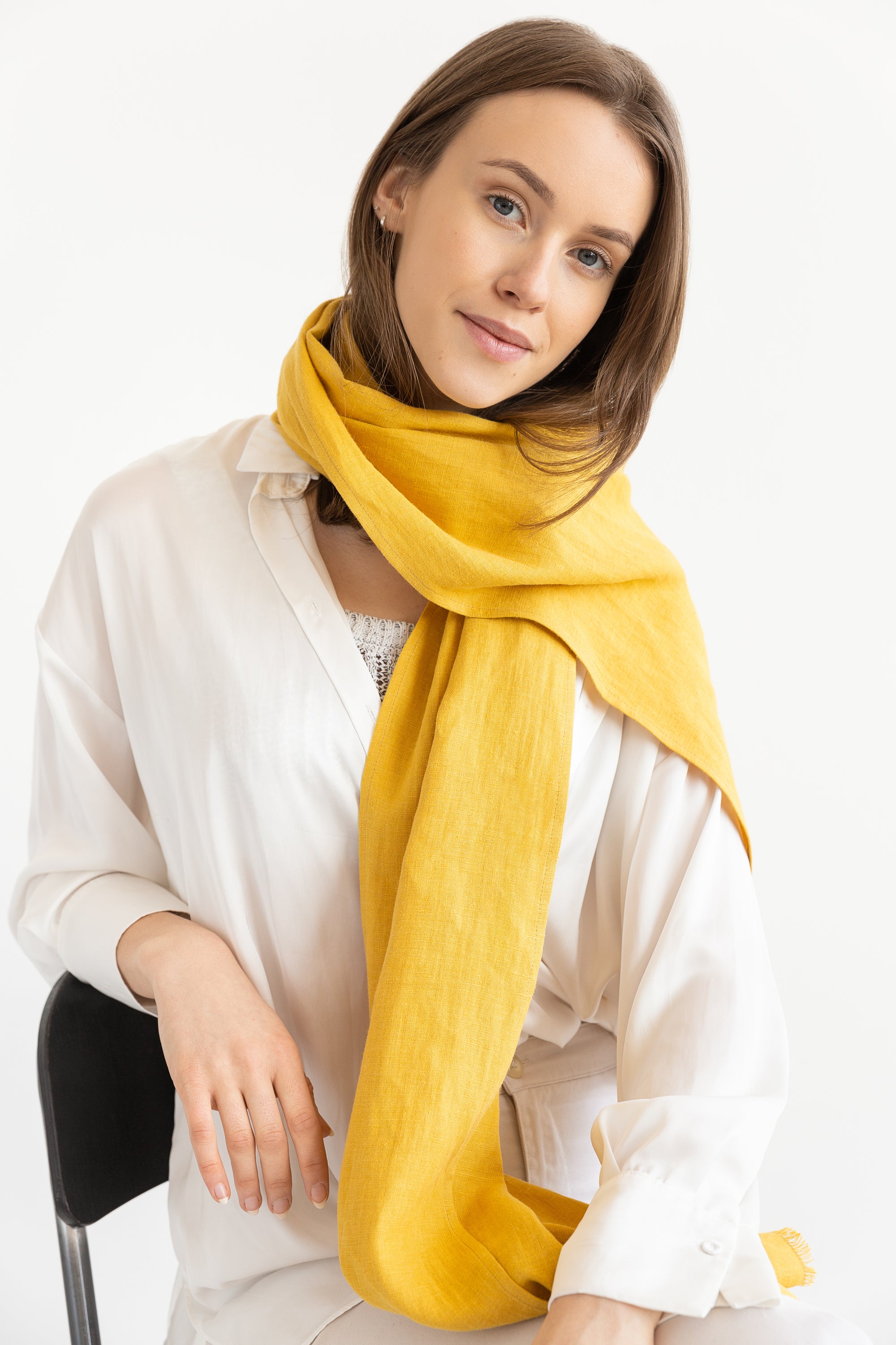 A vibrant collection of lightweight linen scarves in various colors, showcasing their soft texture and stylish design.