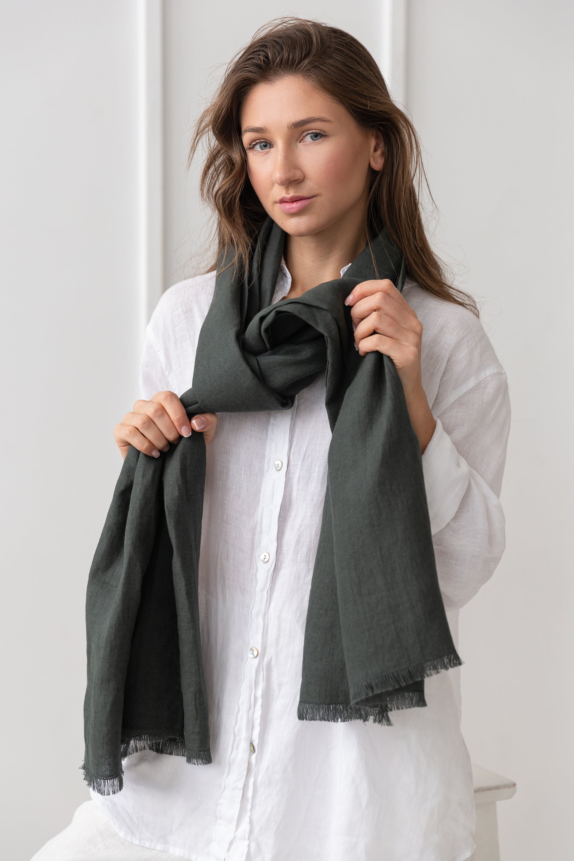 A vibrant collection of lightweight linen scarves in various colors, showcasing their soft texture and stylish design.