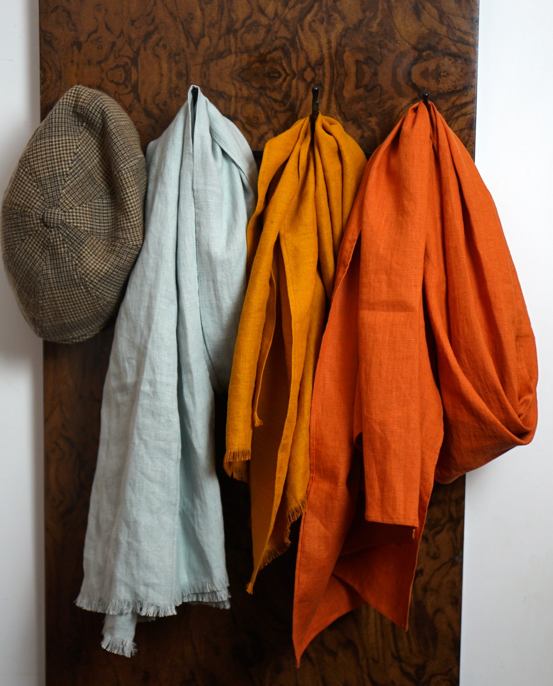 A vibrant collection of lightweight linen scarves in various colors, showcasing their soft texture and stylish design.