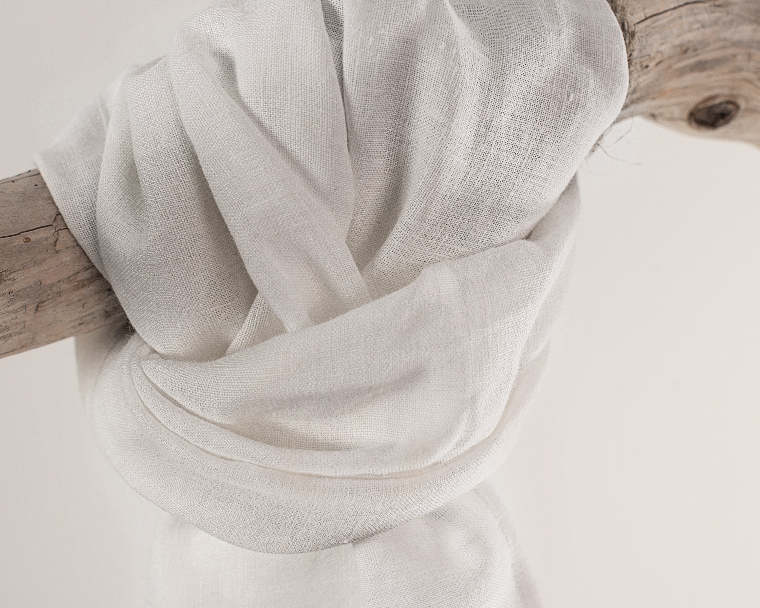 A vibrant collection of lightweight linen scarves in various colors, showcasing their soft texture and stylish design.