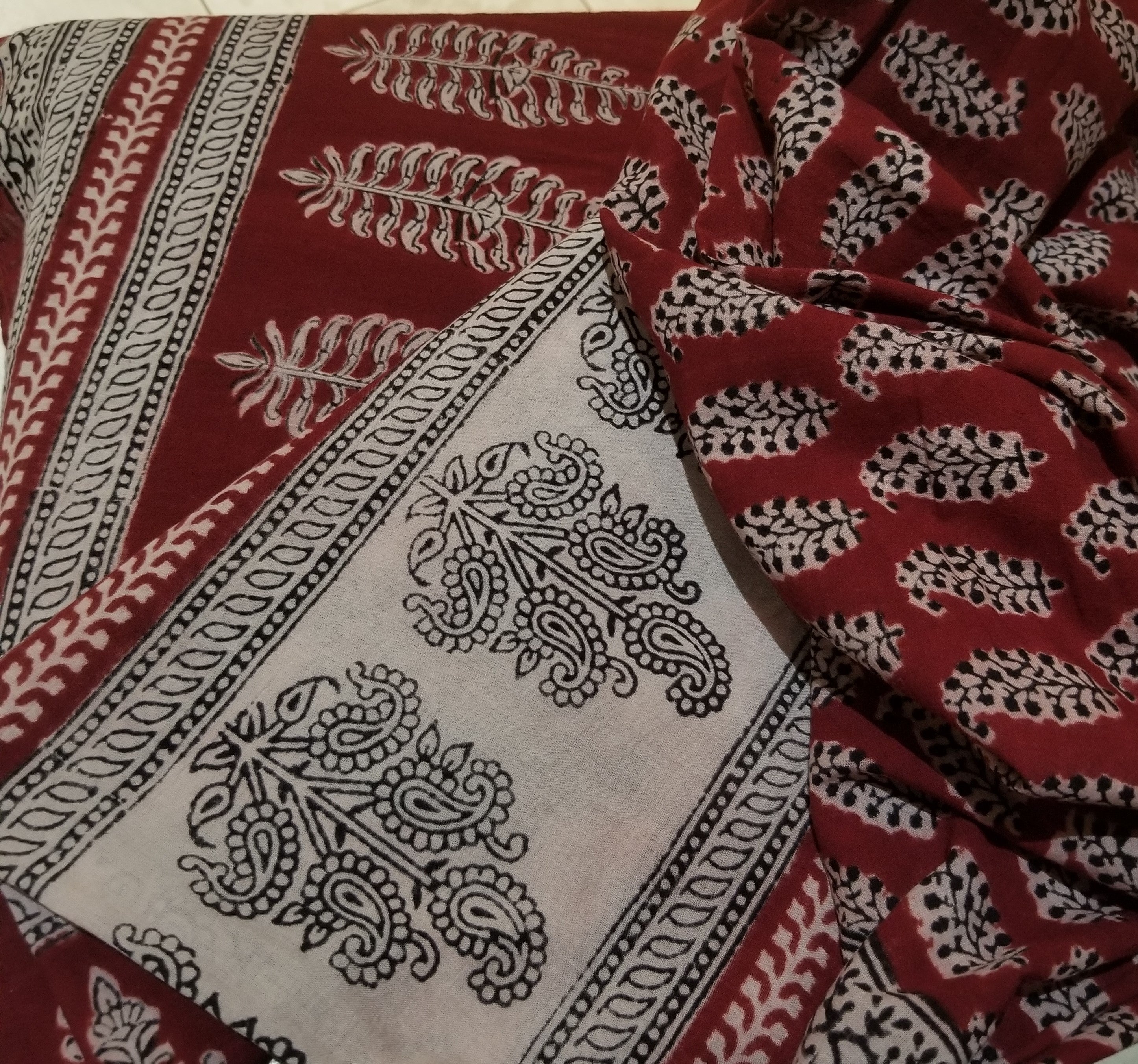 Paisley Design Hand Block Printed cotton fabric featuring intricate red and black patterns on a beige background, showcasing traditional Indian craftsmanship.