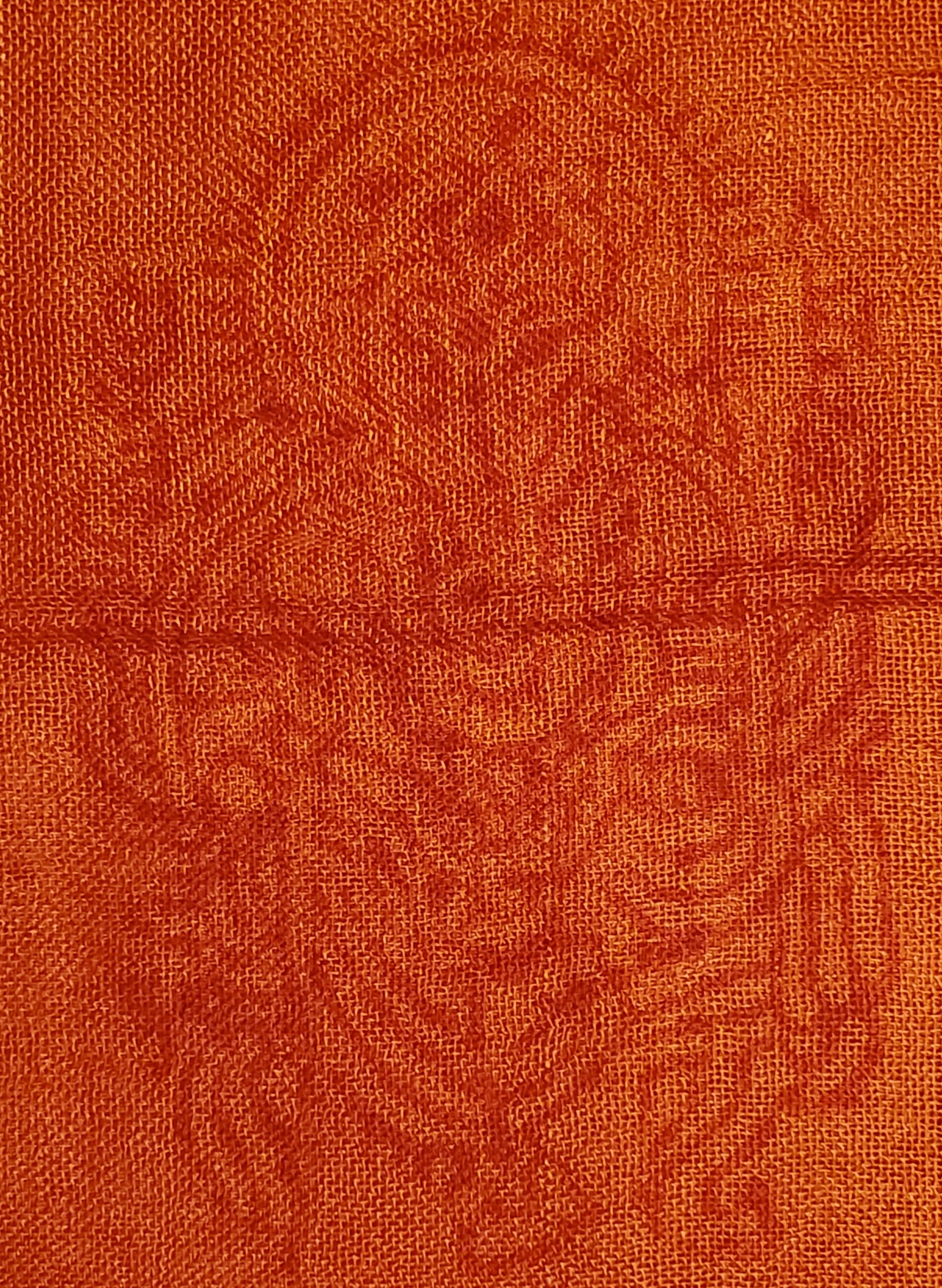 A luxurious red-orange scarf featuring intricate Sanskrit writing and Om symbols, made from 100% cotton.