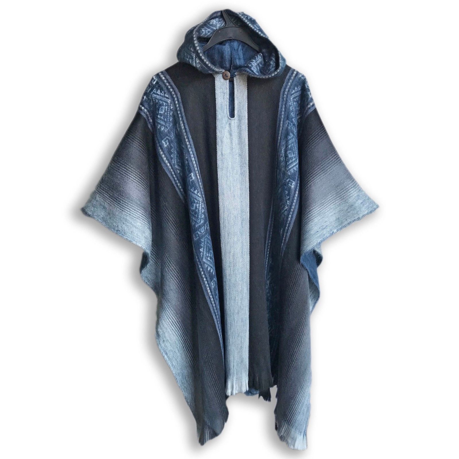 A soft blues and grays alpaca poncho draped elegantly, showcasing its calming colors and luxurious texture.