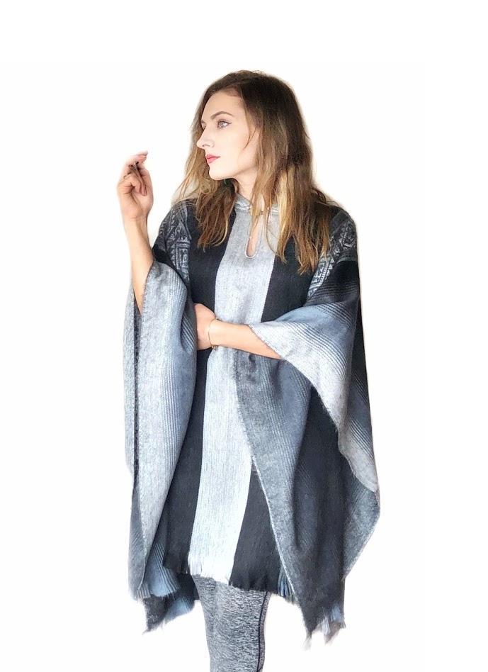 A soft blues and grays alpaca poncho draped elegantly, showcasing its calming colors and luxurious texture.