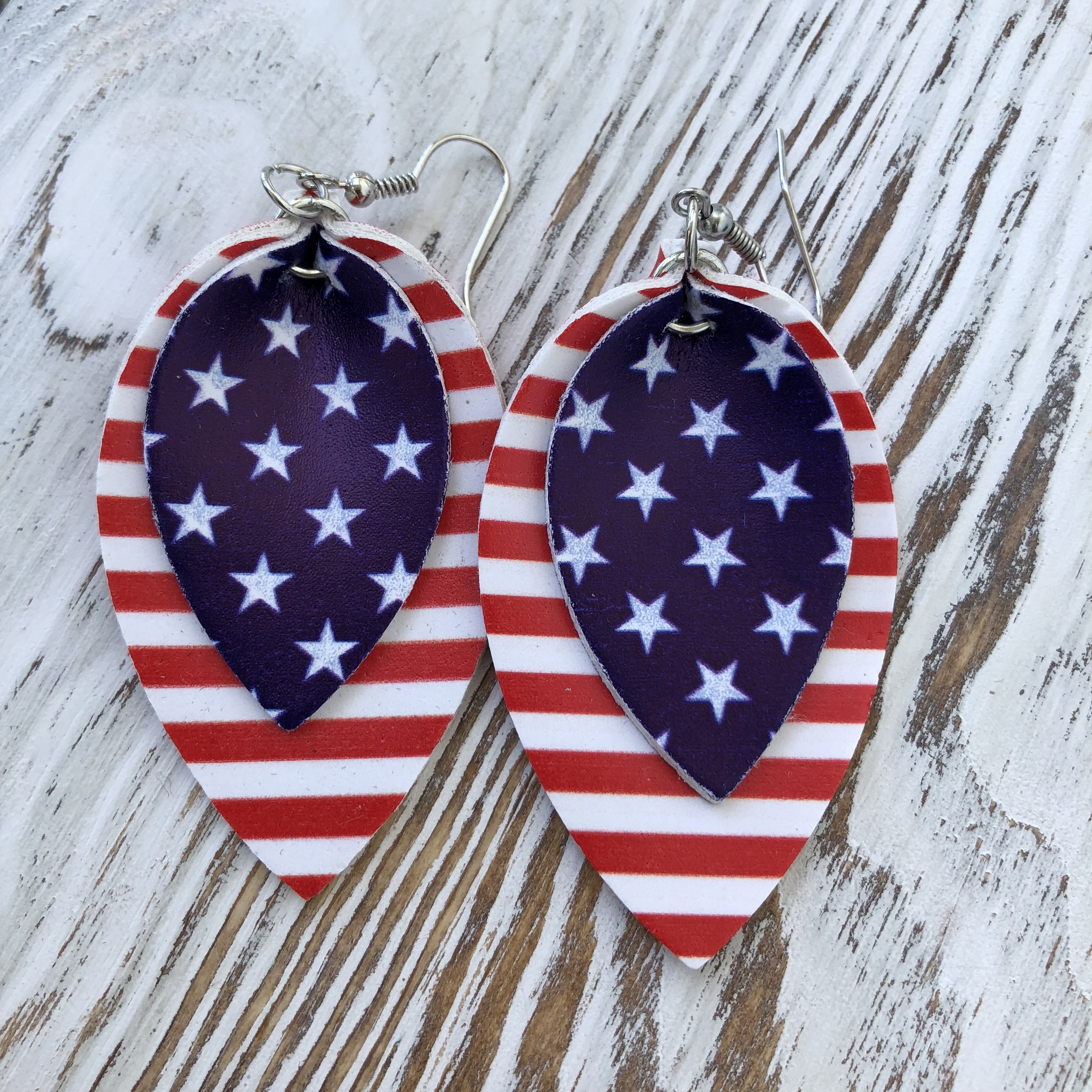 A pair of 4th Of July Teardrop Patriotic Synthetic Leather Earrings in vibrant red, white, and blue colors, featuring a stylish teardrop shape and a lightweight design.