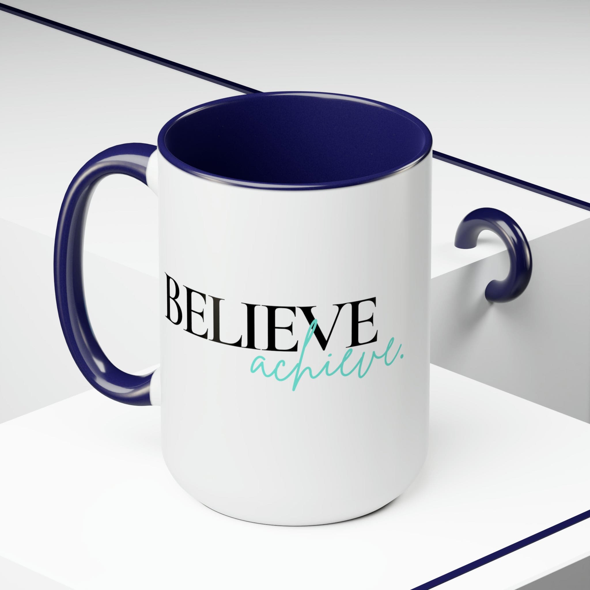 Black ceramic coffee mug with colored interior and handle, featuring the inspirational phrase 'Believe and Achieve'.