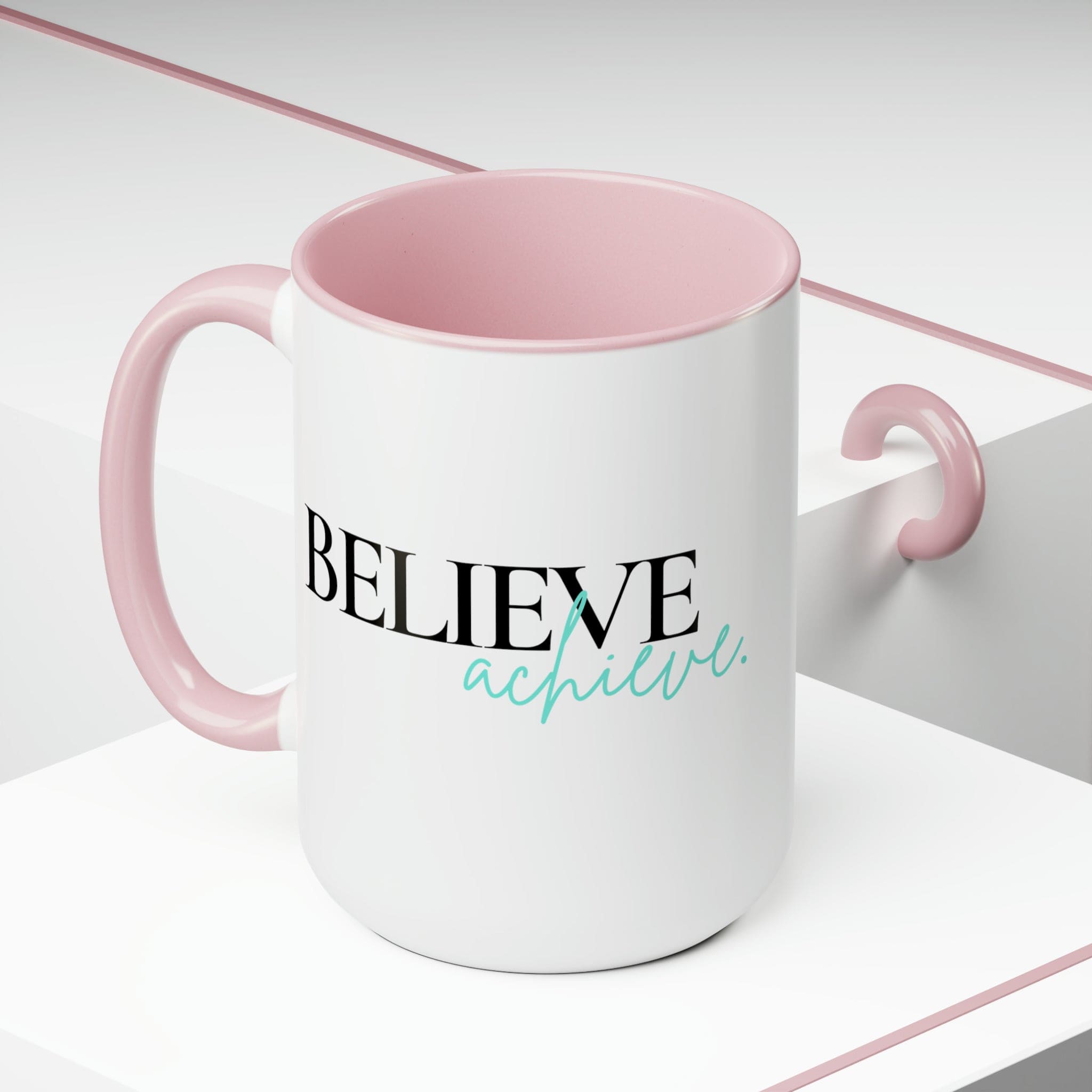 Black ceramic coffee mug with colored interior and handle, featuring the inspirational phrase 'Believe and Achieve'.