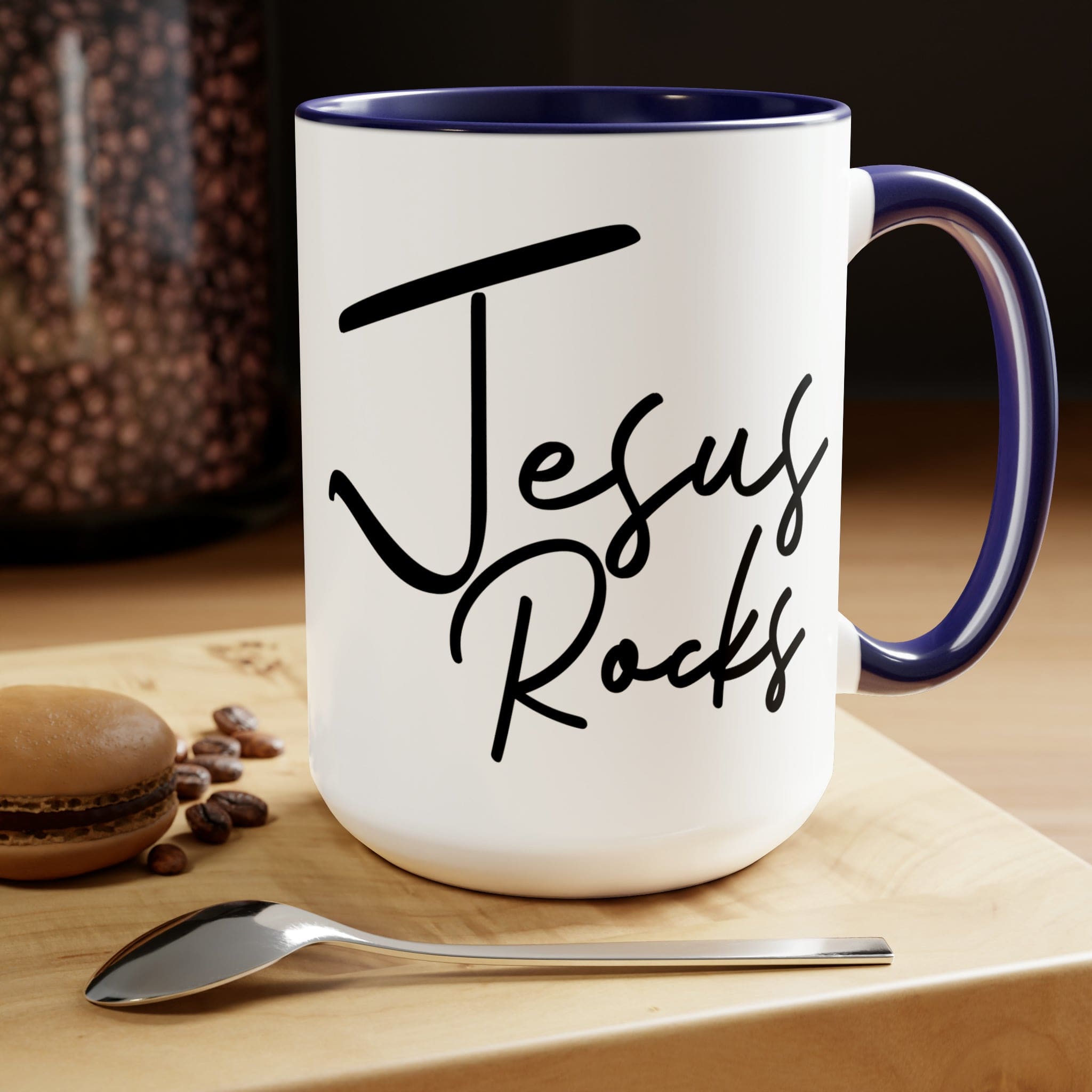 Black ceramic coffee mug with 'Jesus Rocks' text, featuring a colored interior and handle, perfect for hot and cold beverages.