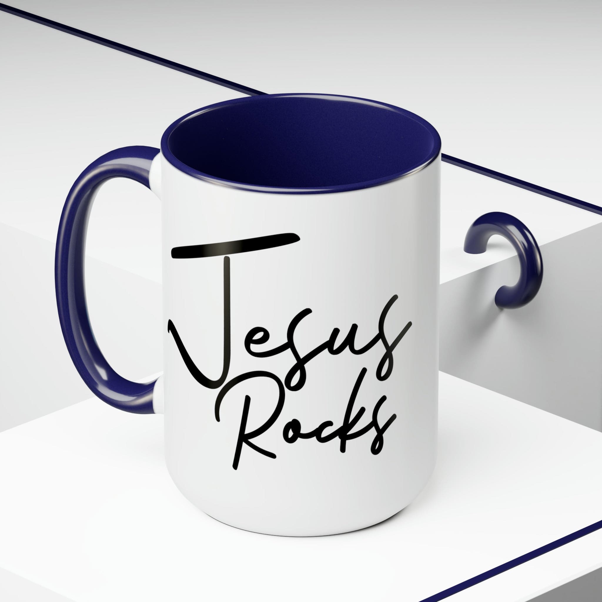 Black ceramic coffee mug with 'Jesus Rocks' text, featuring a colored interior and handle, perfect for hot and cold beverages.