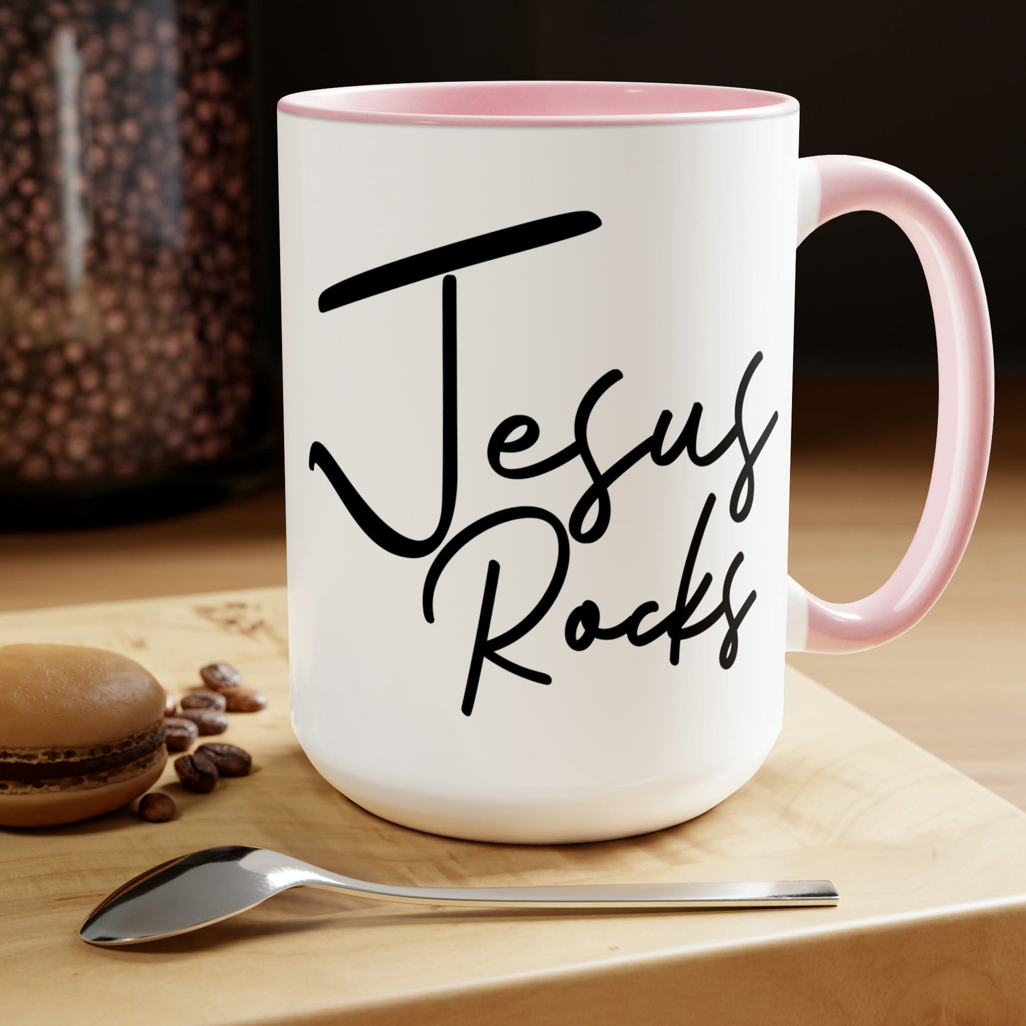 Black ceramic coffee mug with 'Jesus Rocks' text, featuring a colored interior and handle, perfect for hot and cold beverages.