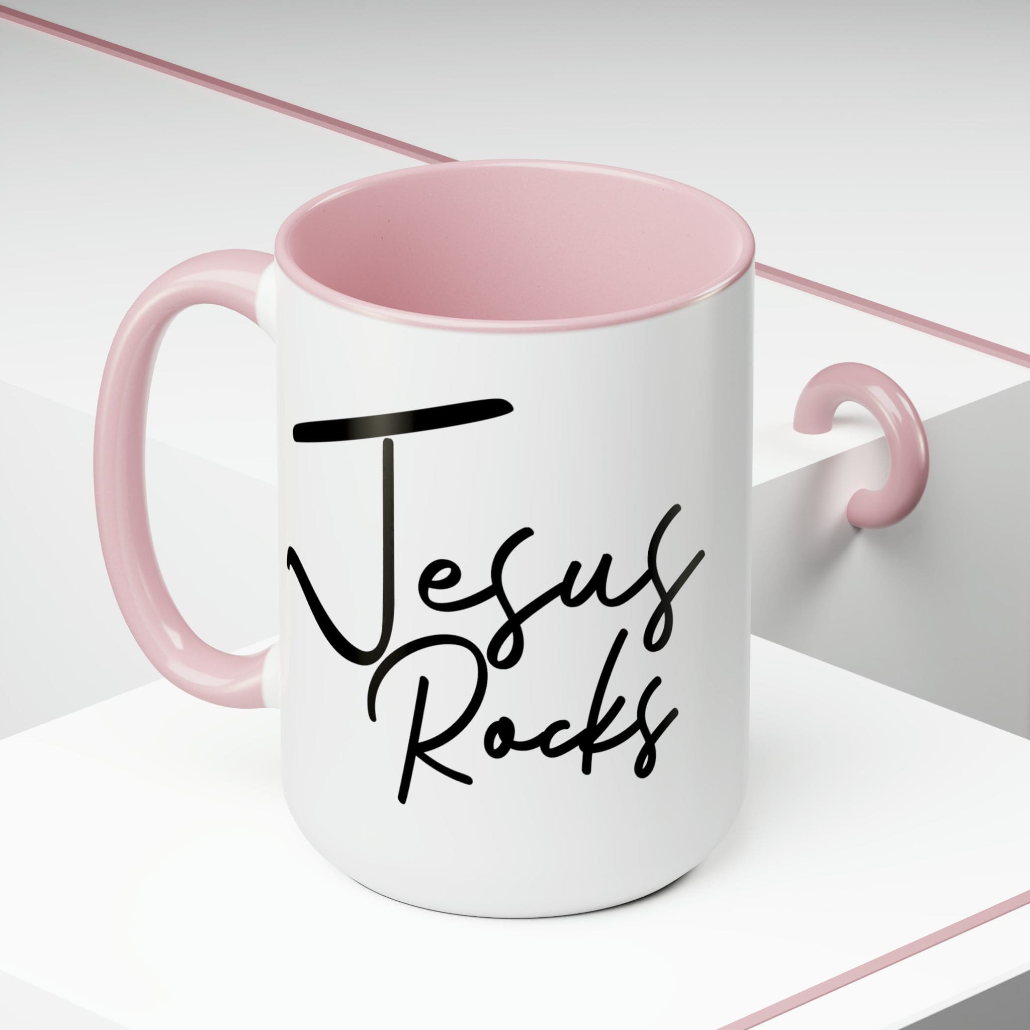 Black ceramic coffee mug with 'Jesus Rocks' text, featuring a colored interior and handle, perfect for hot and cold beverages.