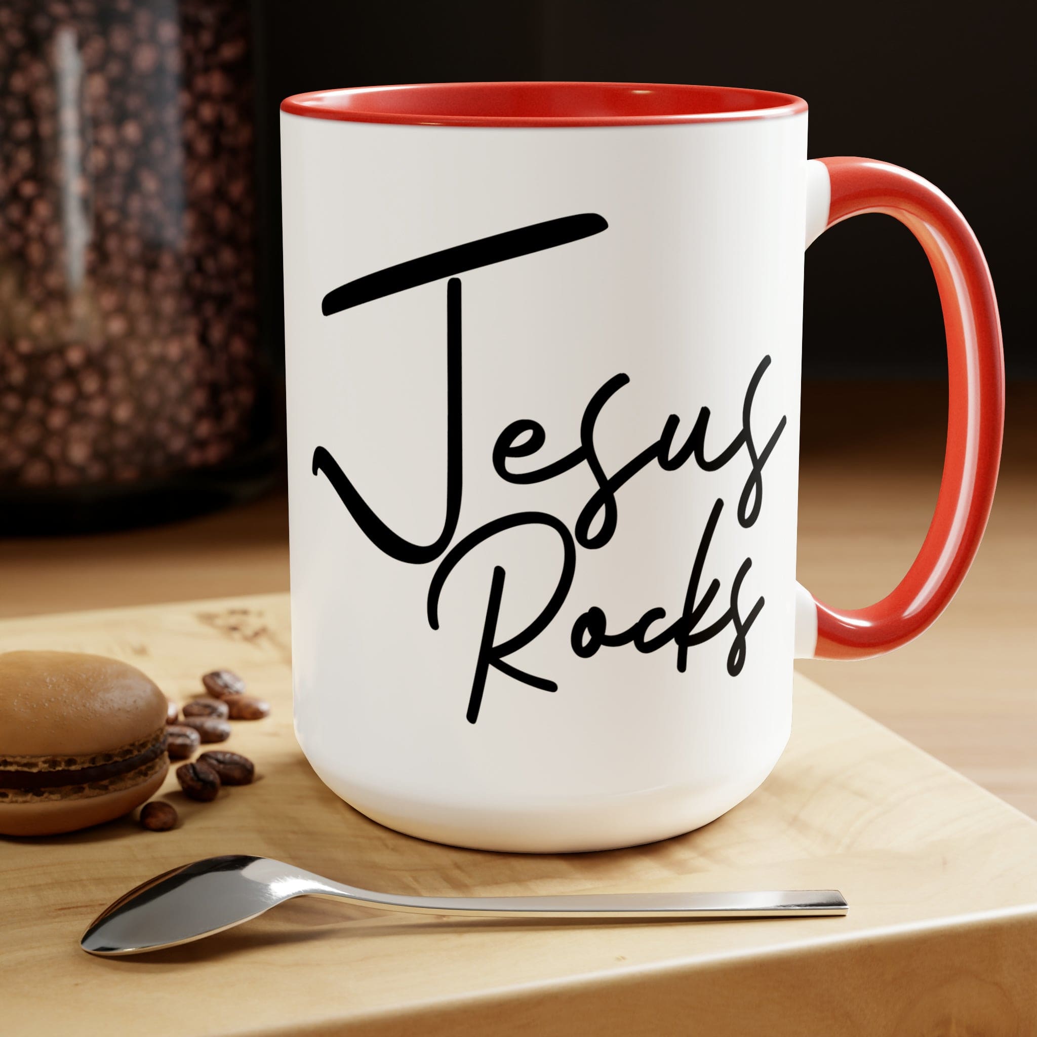 Black ceramic coffee mug with 'Jesus Rocks' text, featuring a colored interior and handle, perfect for hot and cold beverages.