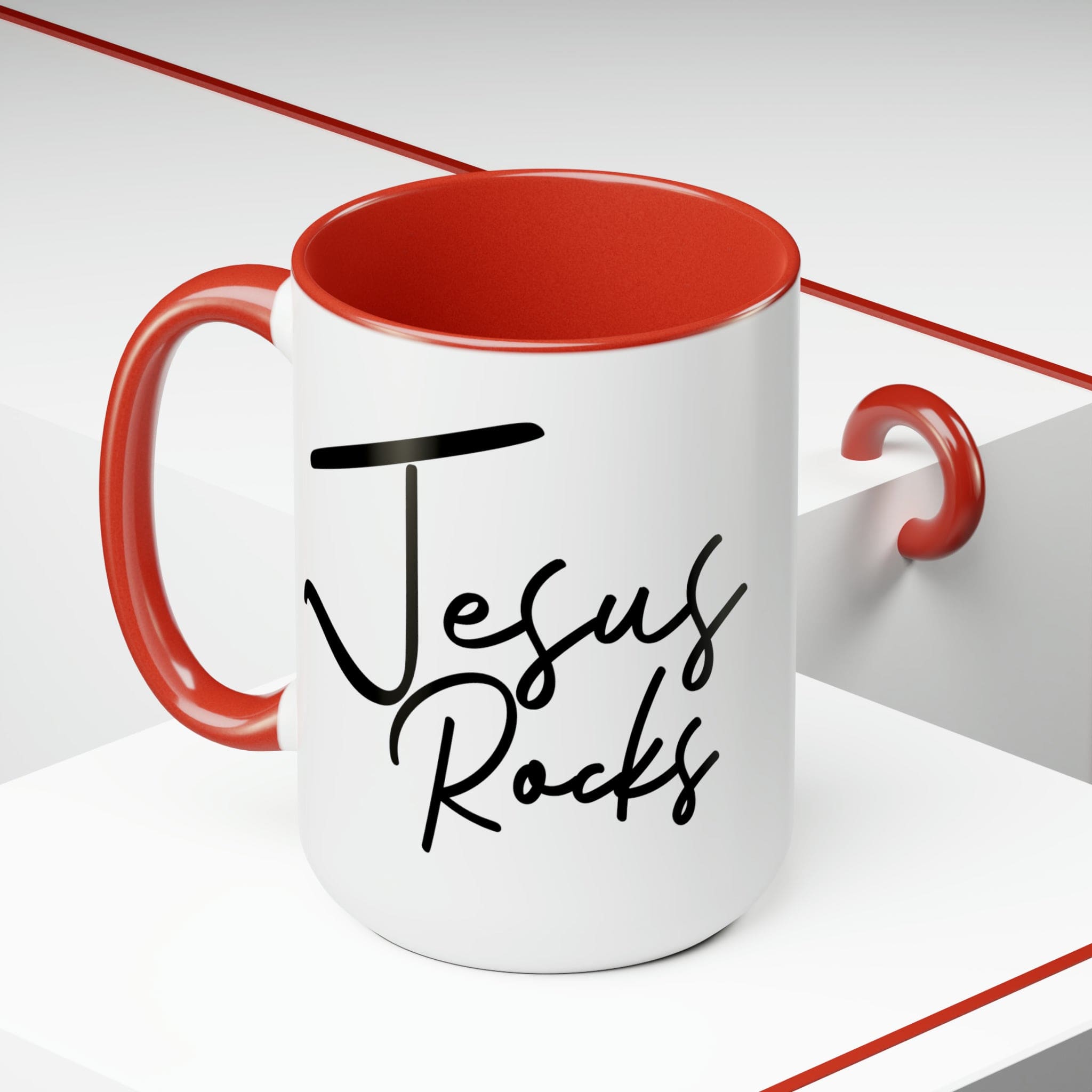 Black ceramic coffee mug with 'Jesus Rocks' text, featuring a colored interior and handle, perfect for hot and cold beverages.