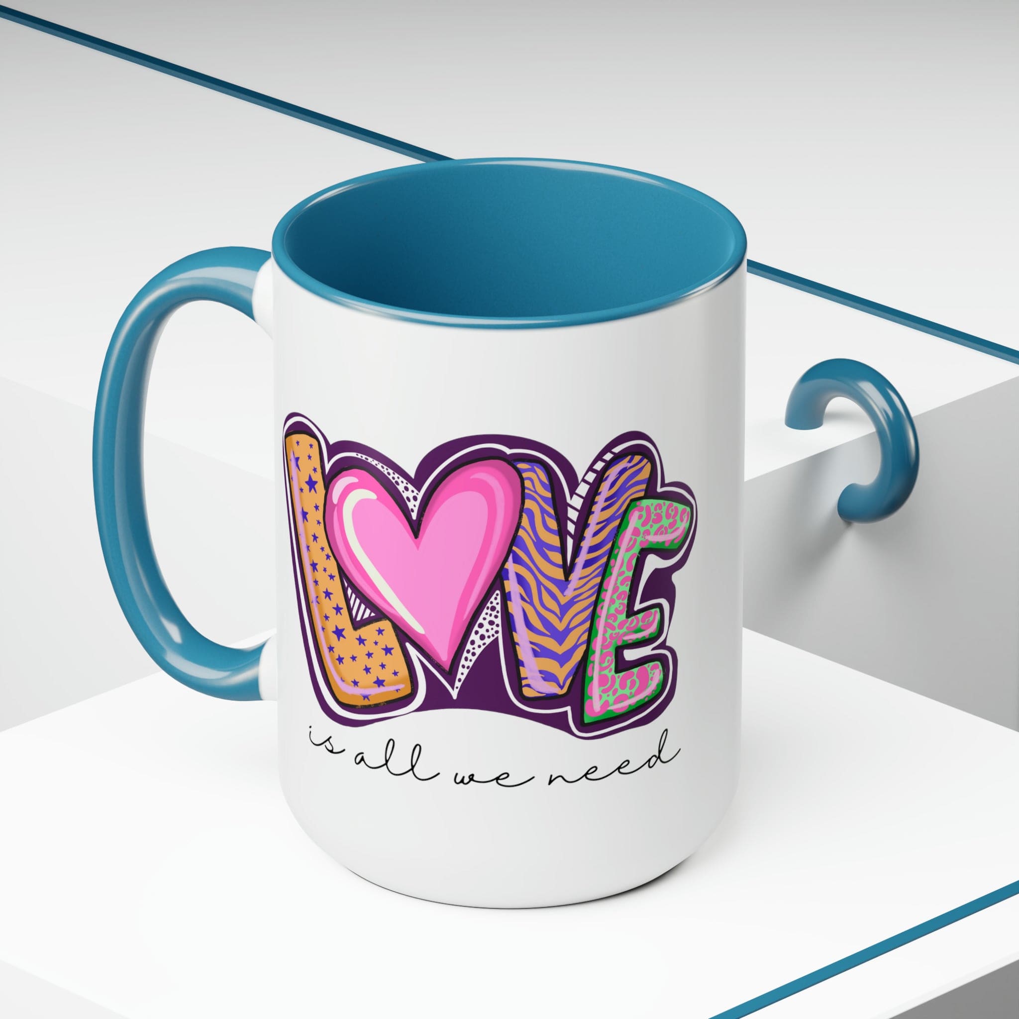 Accent Ceramic Coffee Mug 15oz with a white exterior and colorful interior, featuring the phrase 'Love is All we Need' on the side.