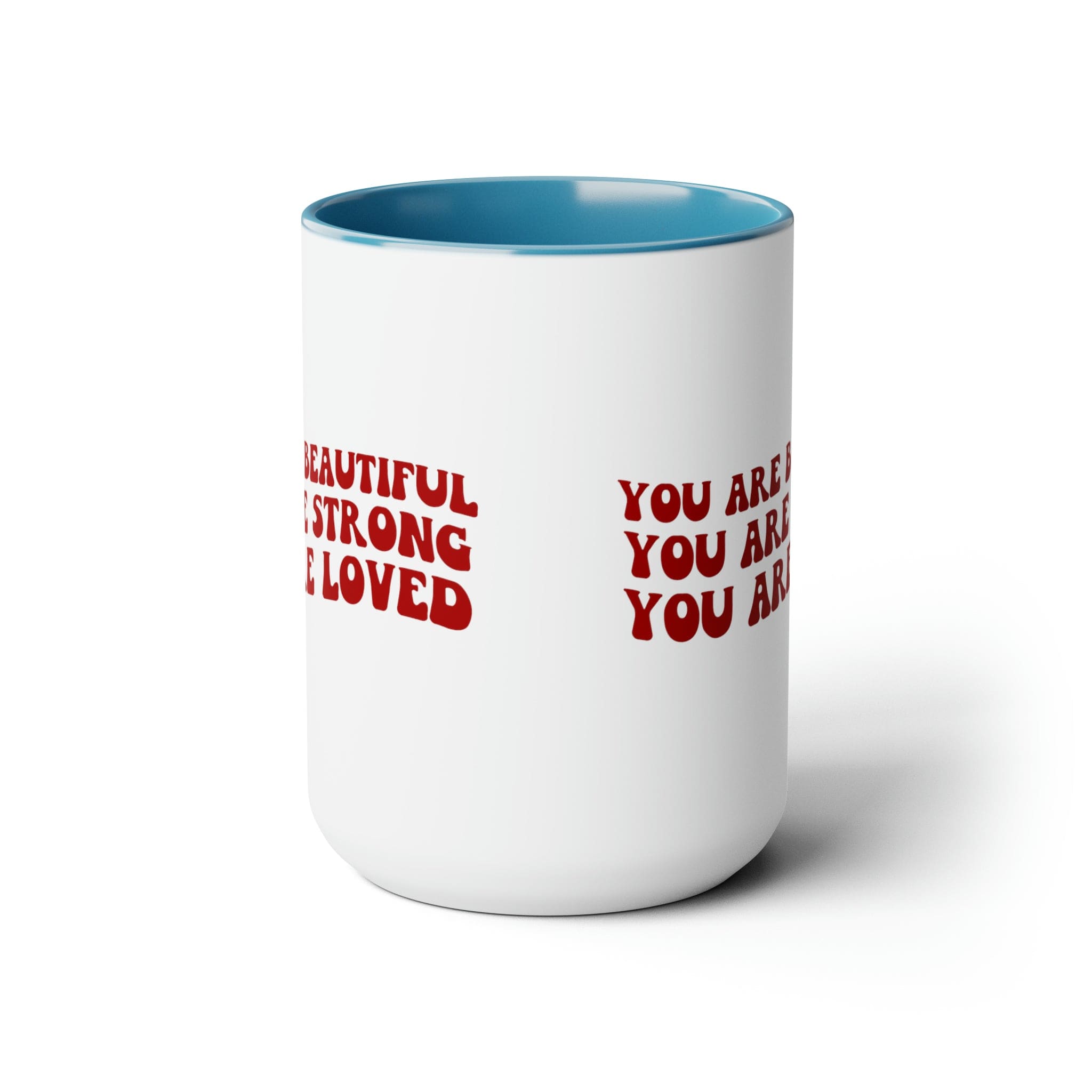 Red ceramic coffee mug with a white exterior and colored interior, featuring the inspirational message 'You Are Beautiful Strong Loved'.