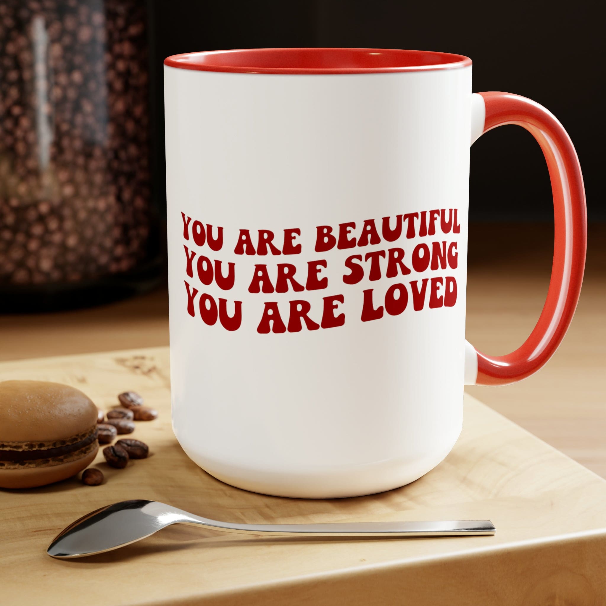 Red ceramic coffee mug with a white exterior and colored interior, featuring the inspirational message 'You Are Beautiful Strong Loved'.