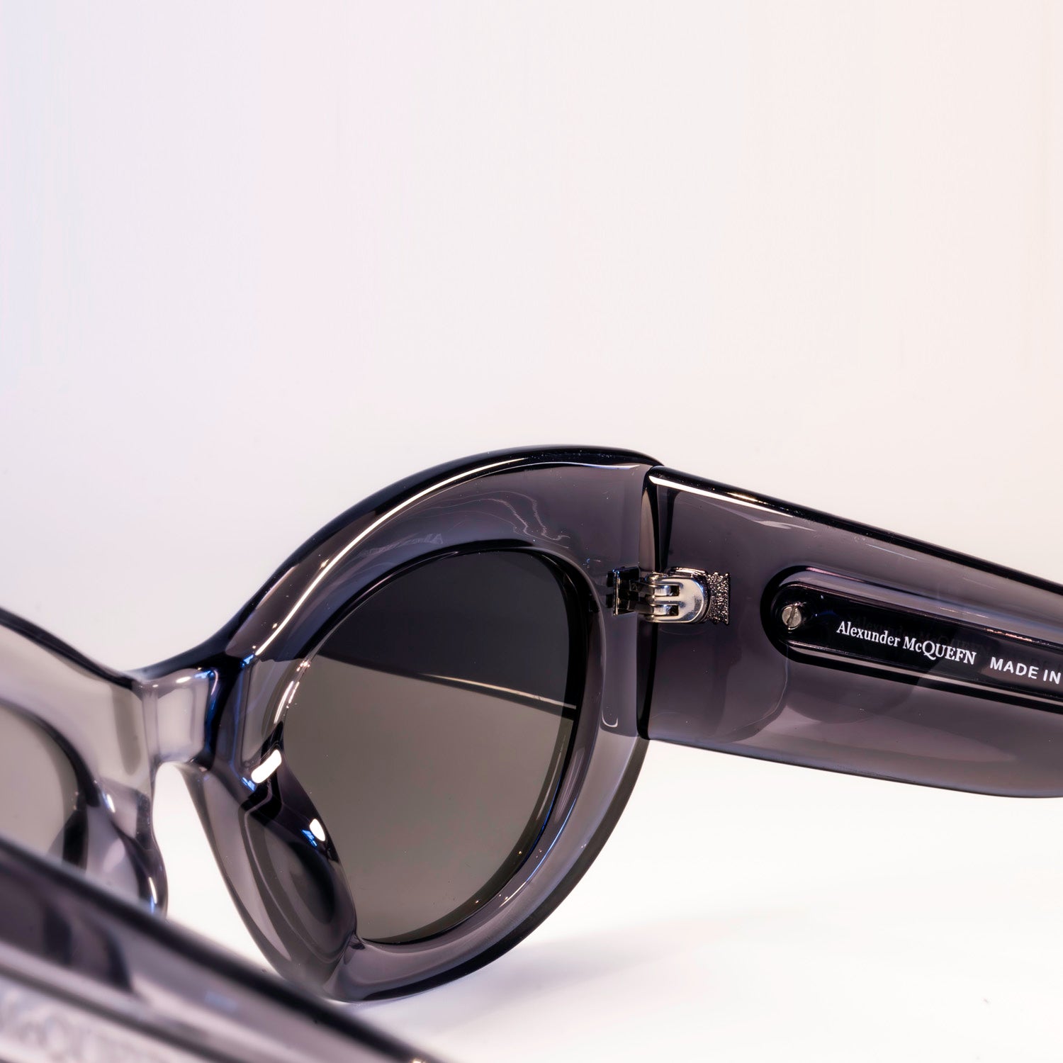 Alexander McQueen AM0403S cat-eye sunglasses with grey gradient lenses and full rim acetate frame.