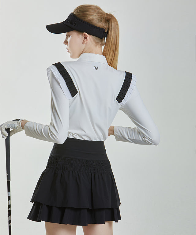 Anna Smock Pleated Skirt in Black featuring a two-tiered design with smocking and flared culottes.