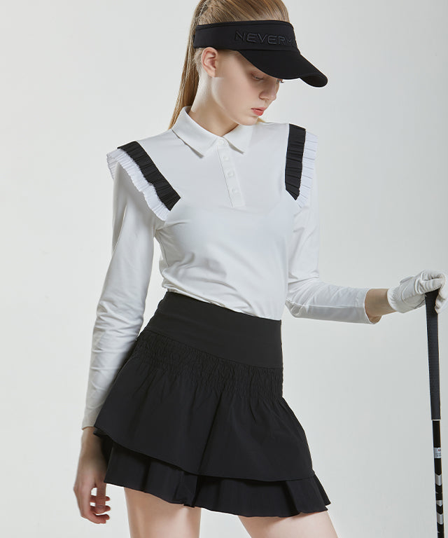 Anna Smock Pleated Skirt in Black featuring a two-tiered design with smocking and flared culottes.