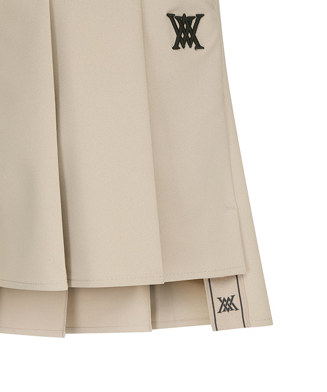 ANEW Golf Women's Buckle Decoration Pleats Skirt in Beige, showcasing pleats and buckle details.