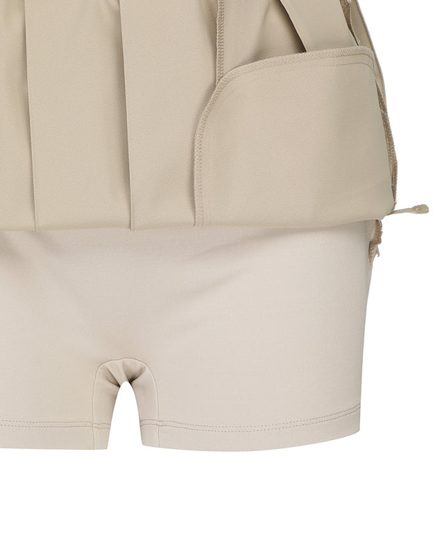 ANEW Golf Women's Buckle Decoration Pleats Skirt in Beige, showcasing pleats and buckle details.