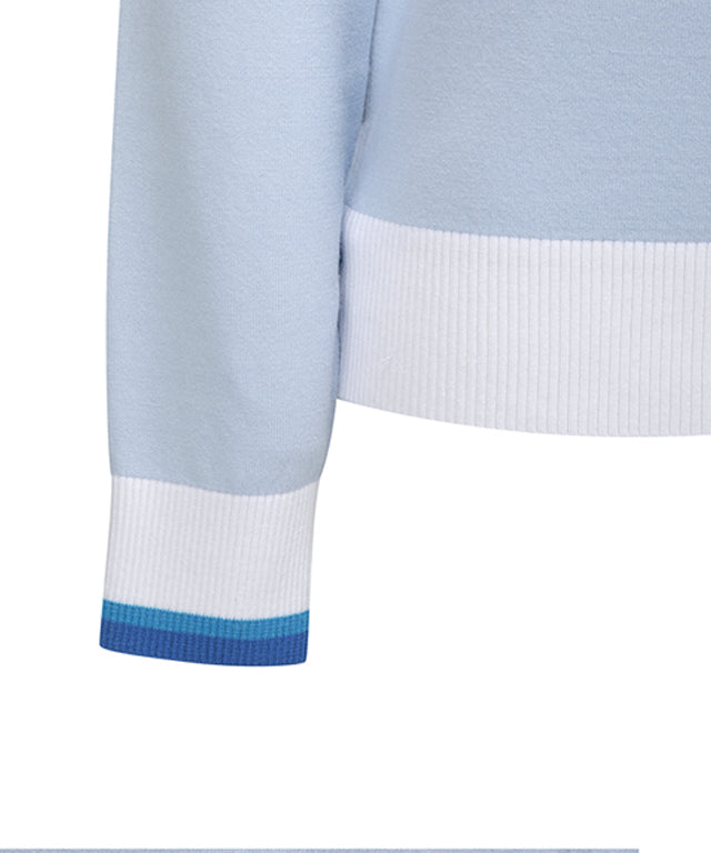 Sky blue knitted pullover sweater for women with logo and pastel color combination, featuring a round neck and button detail at the hem.