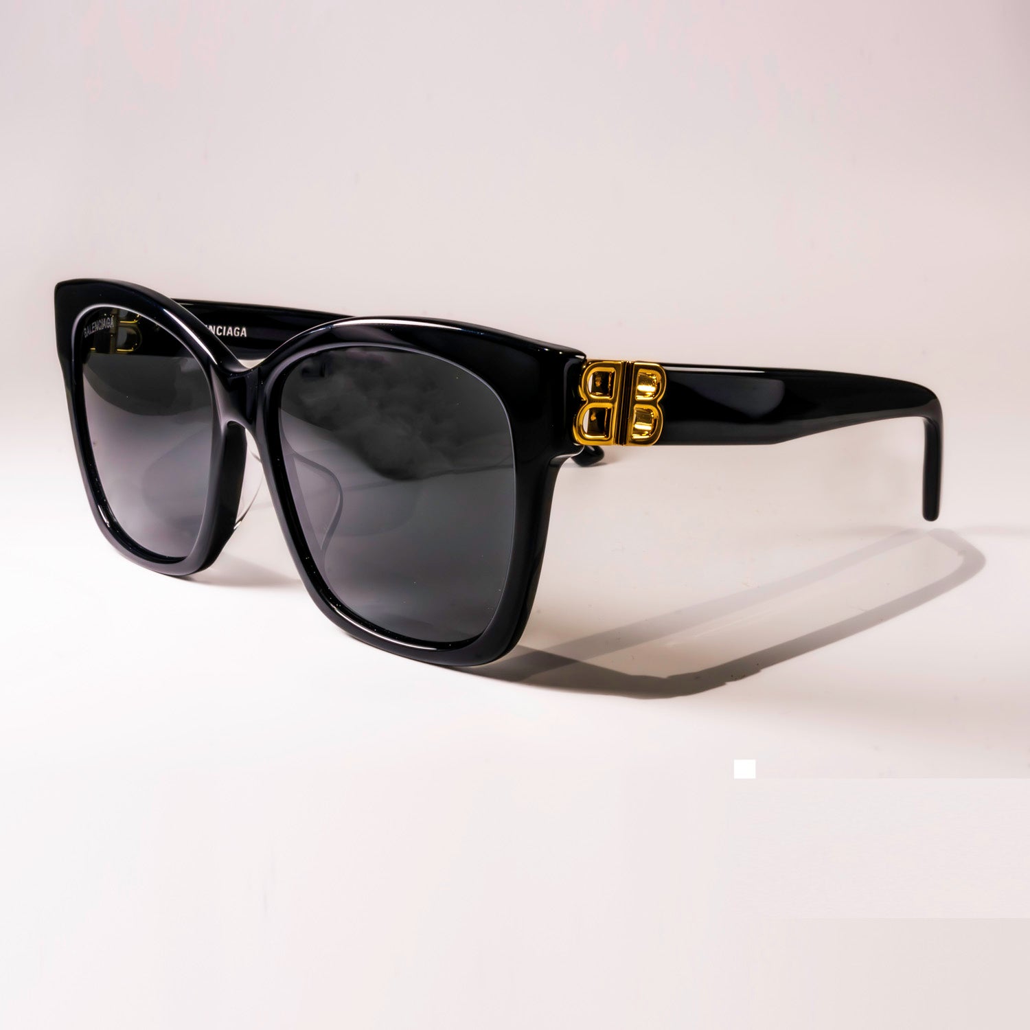 BALENCIAGA SUNGLASSES BB0102SA 001 with black frame and grey shiny lenses, showcasing luxury and style.