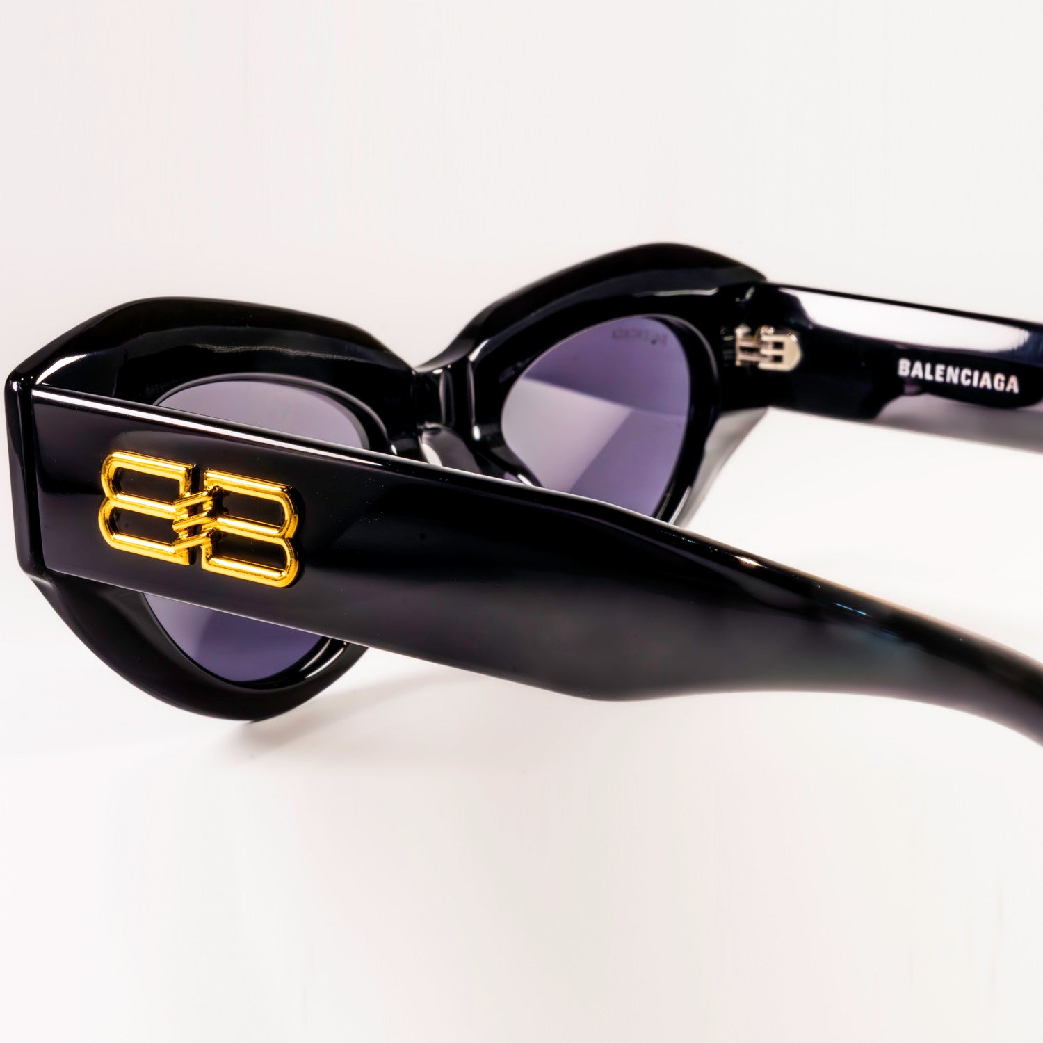 BALENCIAGA SUNGLASSES BB0236S featuring cat-eye shape and grey lenses, set against a stylish background.