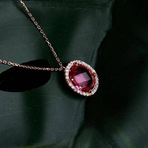 Beatrice Oval Gemstone Pendant Necklace in rose gold featuring a pink tourmaline stone surrounded by cubic zirconia accents.