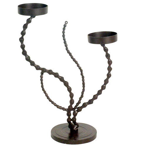 A contemporary candle holder shaped like a flower, made from recycled bicycle chains, showcasing intricate metalwork and eco-friendly design.