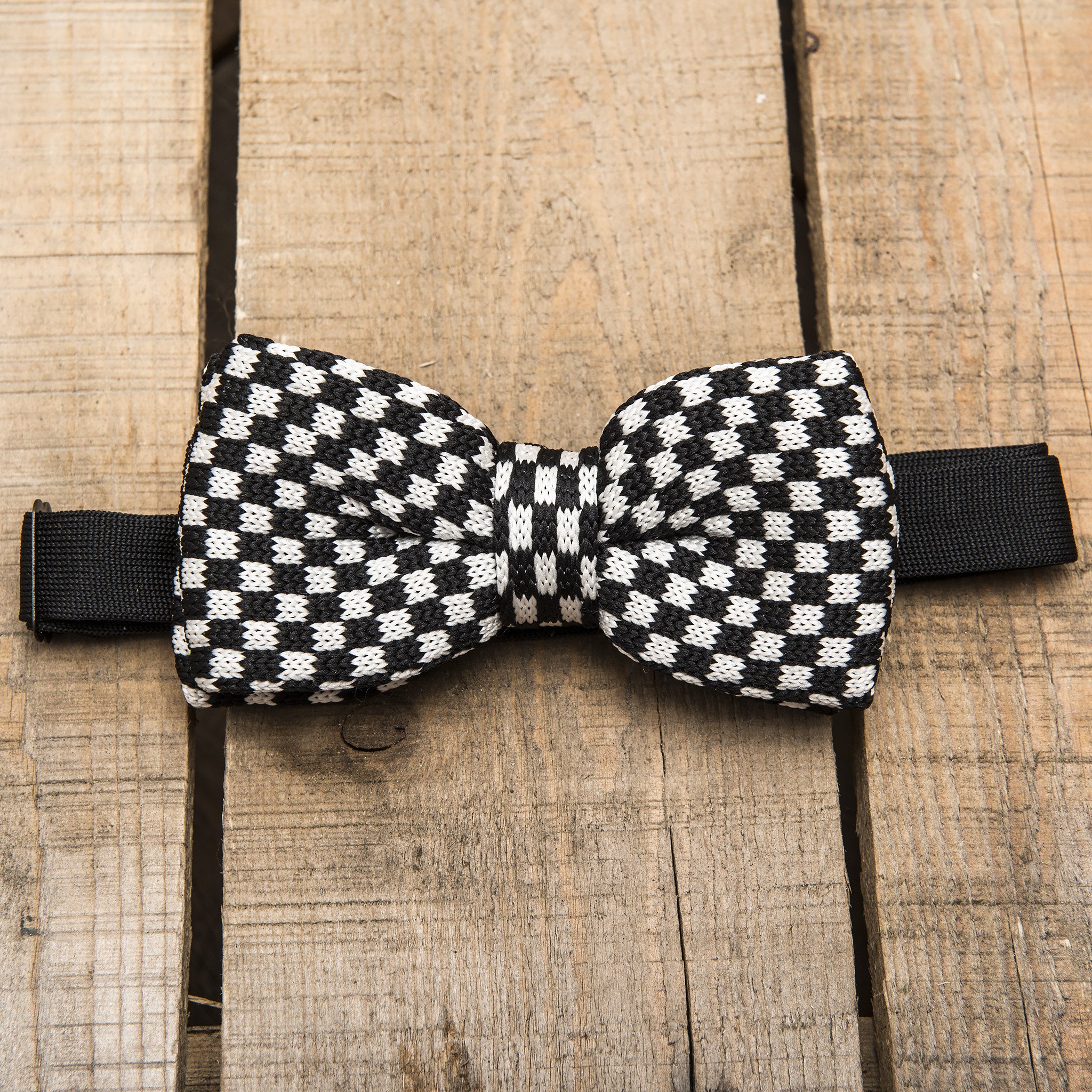 A stylish black and white chequered bow tie, handmade and pre-tied, perfect for formal occasions.