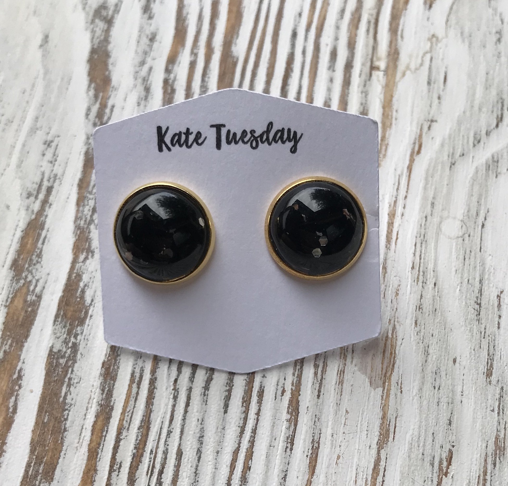 A pair of 12mm black glitter earrings designed for Halloween, showcasing a sparkling finish and lightweight design.